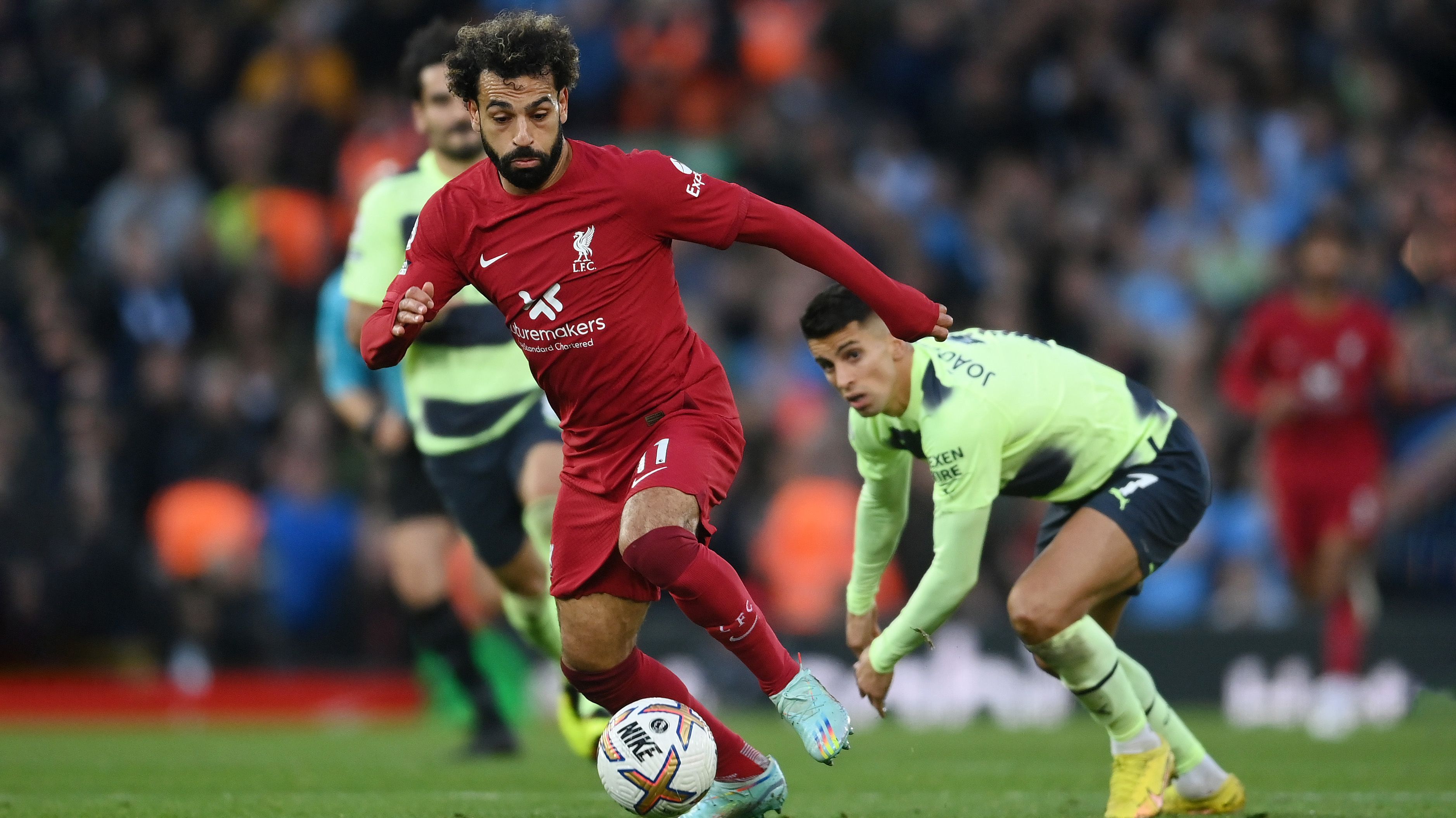 Mohamed Salah del Liverpool se aleja de Joao Cancelo de Manchester City para marcar el primer gol de su equipo durante el partido de la Premier League entre Liverpool FC y Manchester City en Anfield el 16 de octubre de 2022 en Liverpool, Inglaterra.