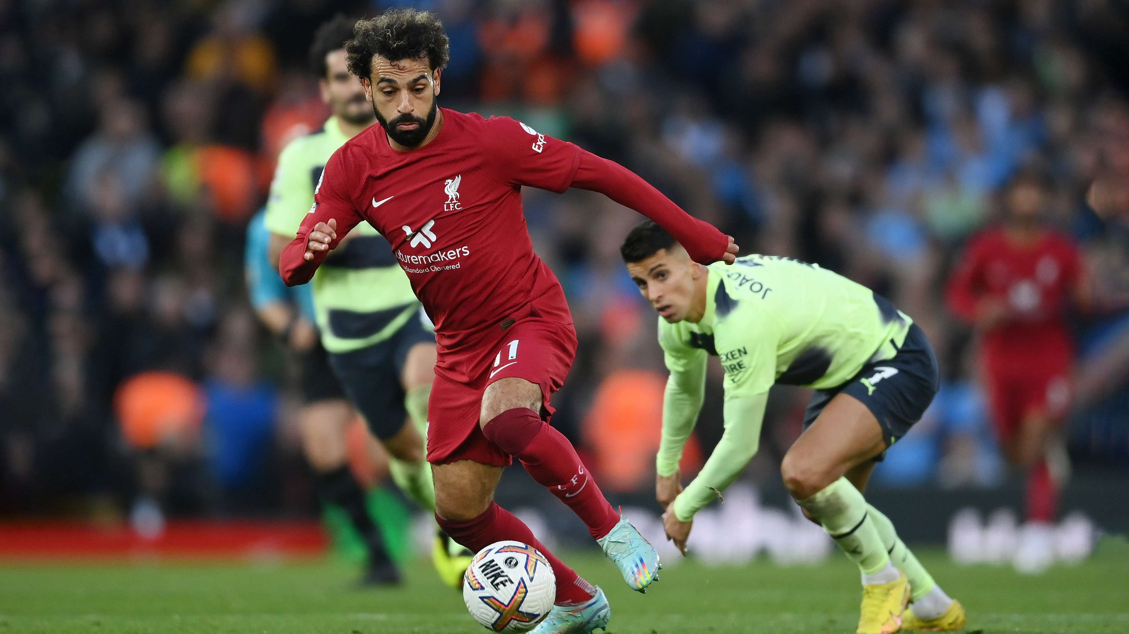 Mohamed Salah del Liverpool se aleja de Joao Cancelo de Manchester City para marcar el primer gol de su equipo durante el partido de la Premier League entre Liverpool FC y Manchester City en Anfield el 16 de octubre de 2022 en Liverpool, Inglaterra.
