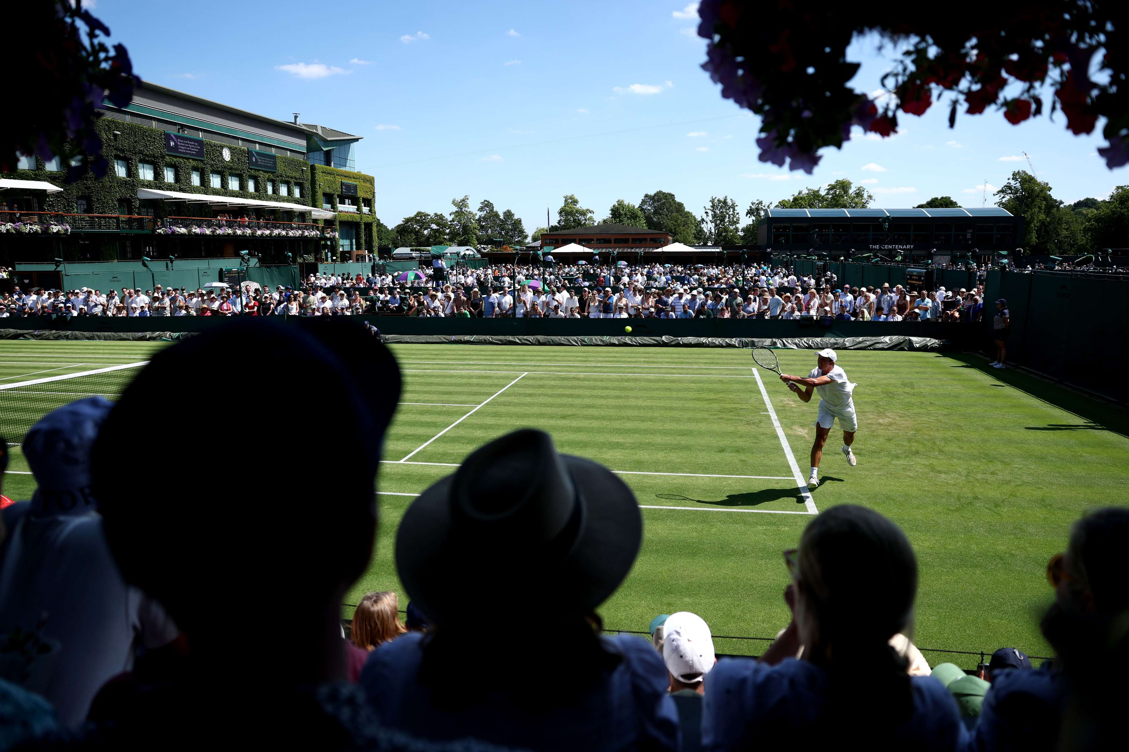 Spectators watch as Oliver Tarvet of Great Britain Wimbledon Championships