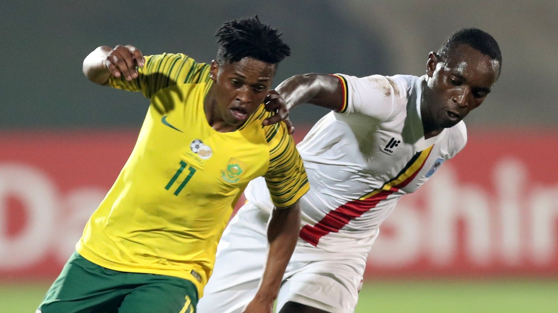 Luther Singh of Bafana Bafana challenged by Nicholas Kasozi of Uganda, June 2019