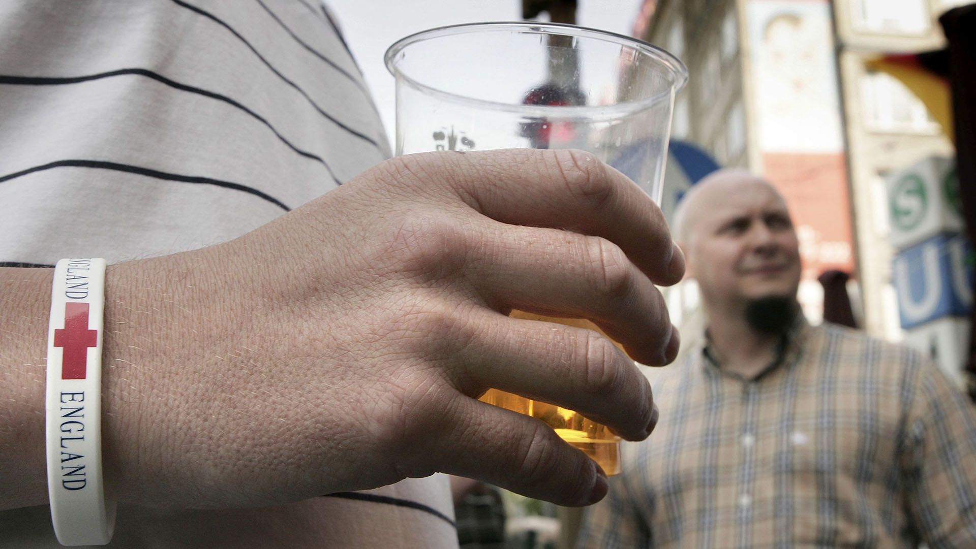 Torcedor bebendo cerveja em copo