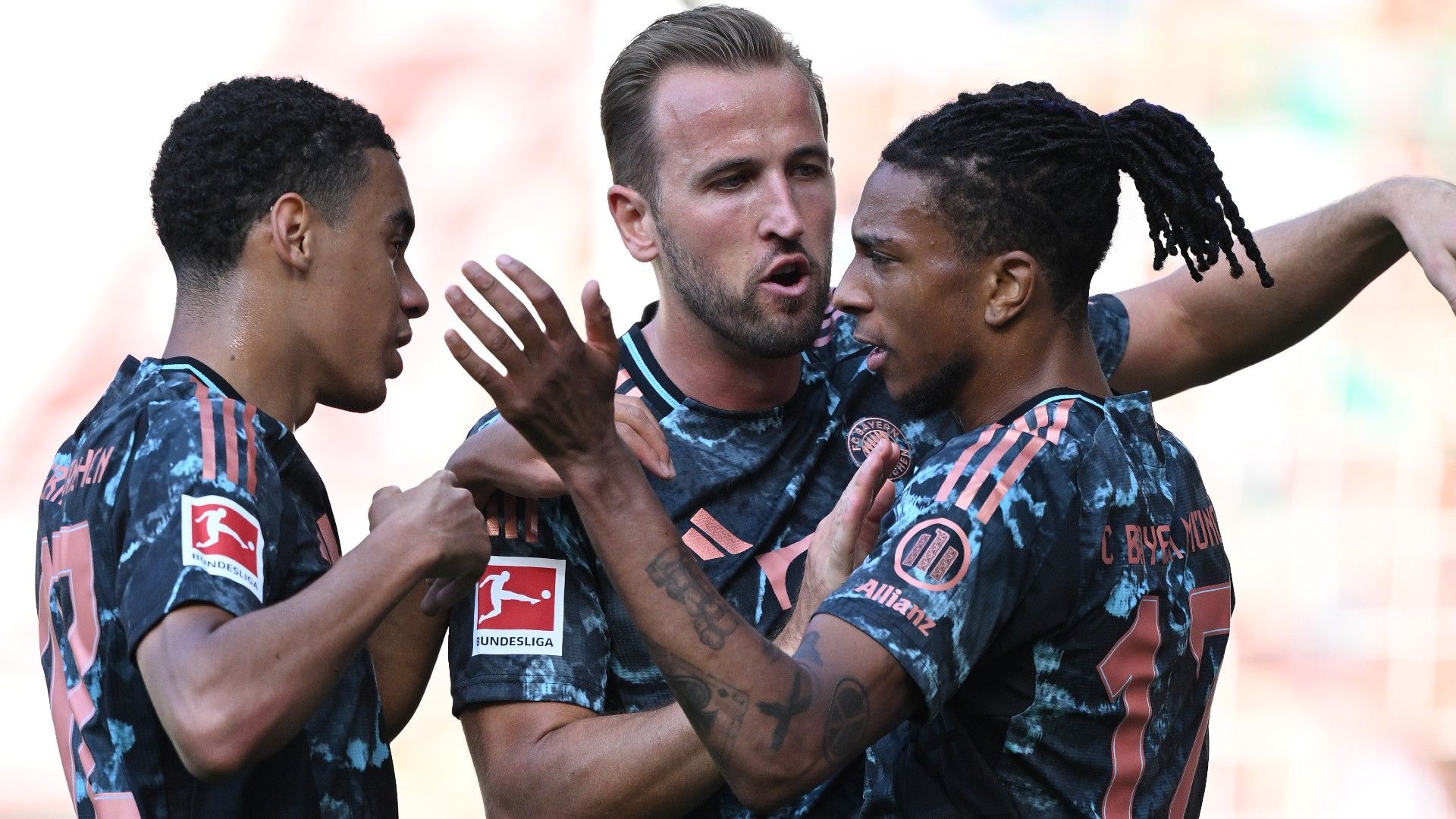 Michael Olise of Bayern Munich celebrates with Jamal Musiala and Harry Kane
