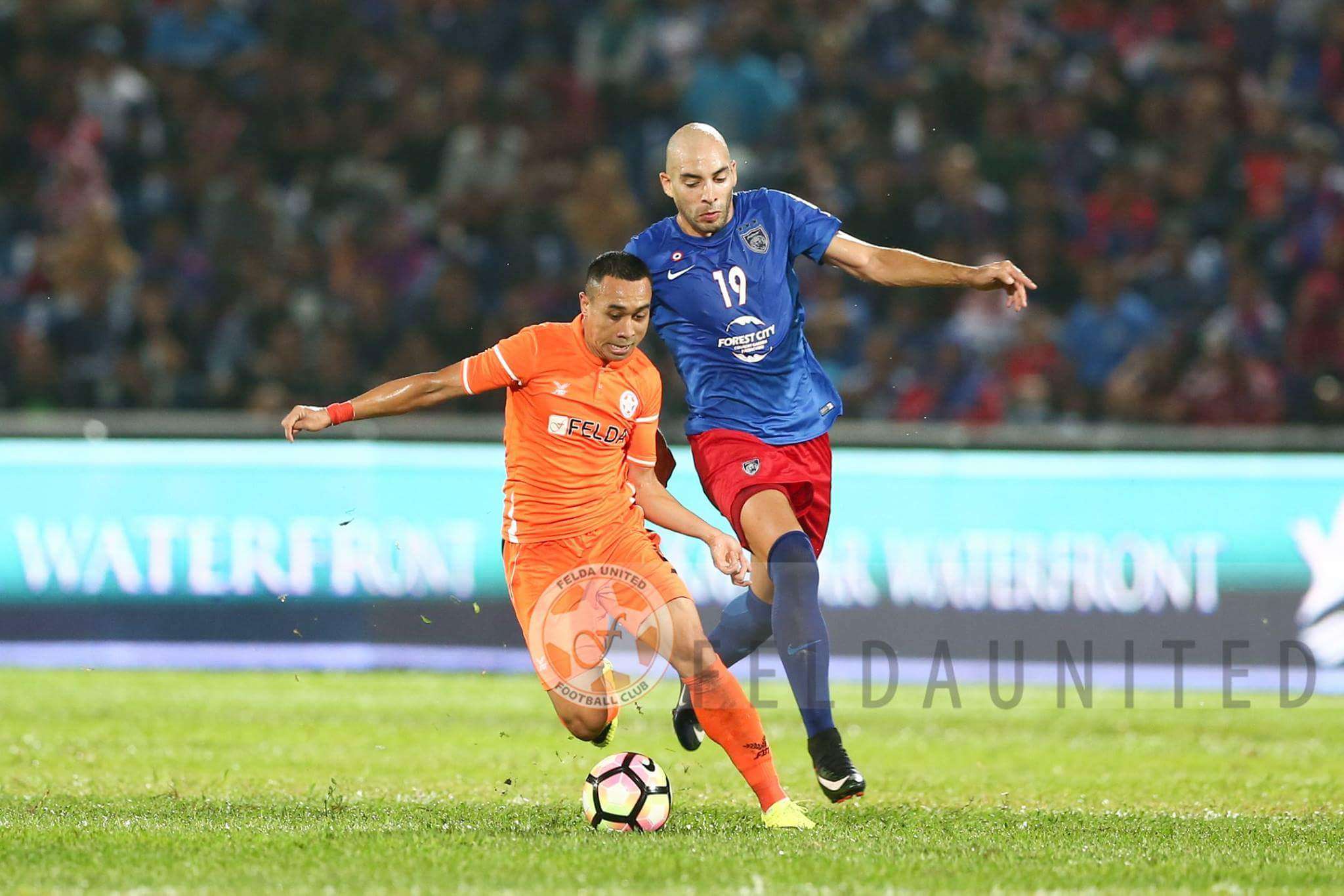 Felda United's Norshahrul Idlan Talaha (left) vies for the ball with Johor Darul Ta'zim'sJerónimo Barrales 27/1/2017