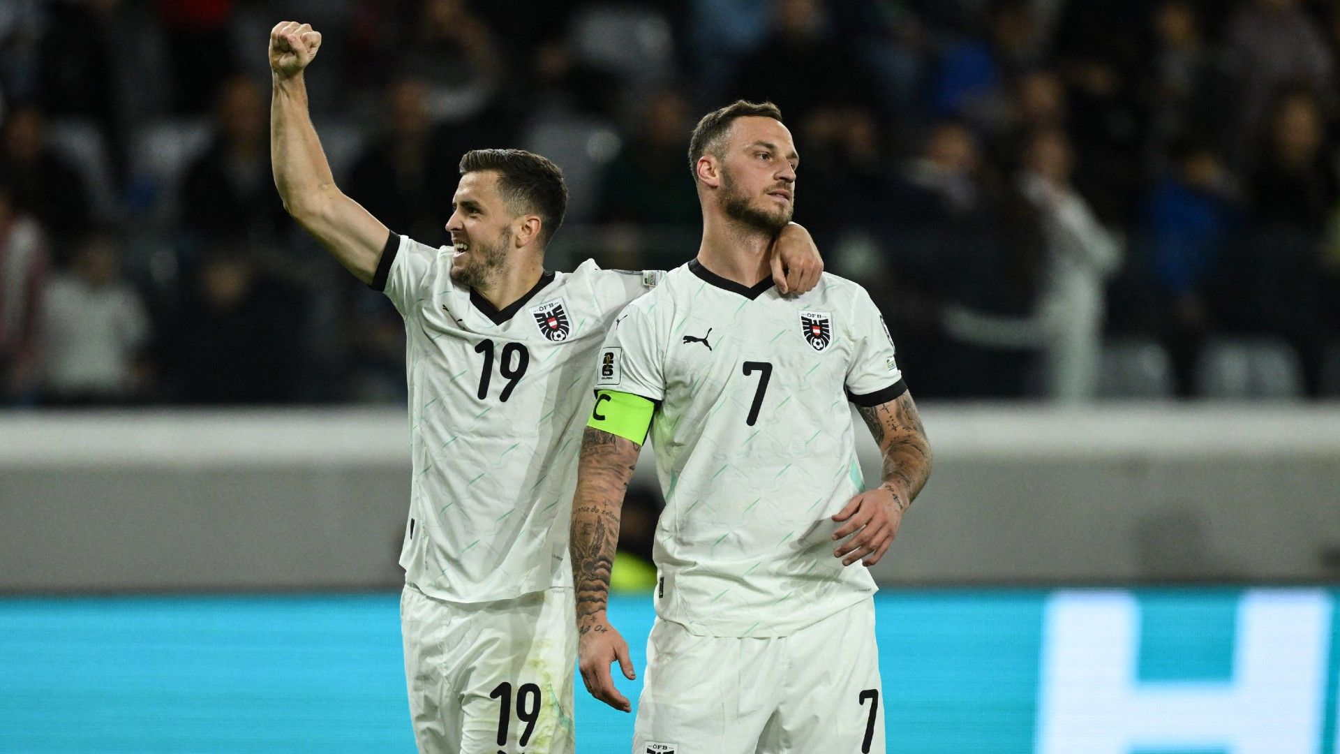 Austria's forward #07 Marko Arnautovic (R) celebrates with Austria's midfielder #19 Christoph Baumgartner 