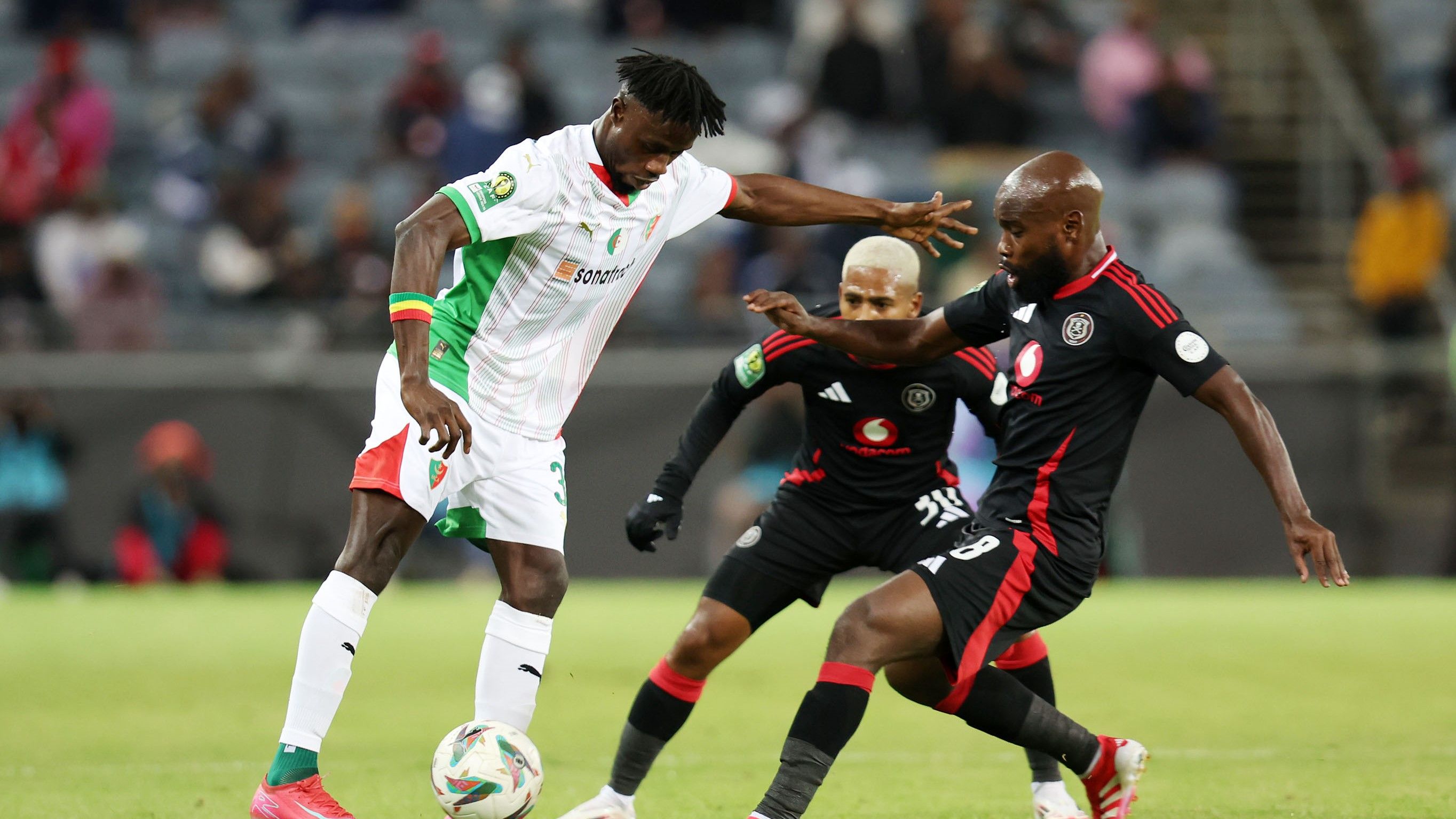 Mohamed Saliiu Bangoura of MC Alger challenged by Makhehleni Makhaula of Orlando Pirates