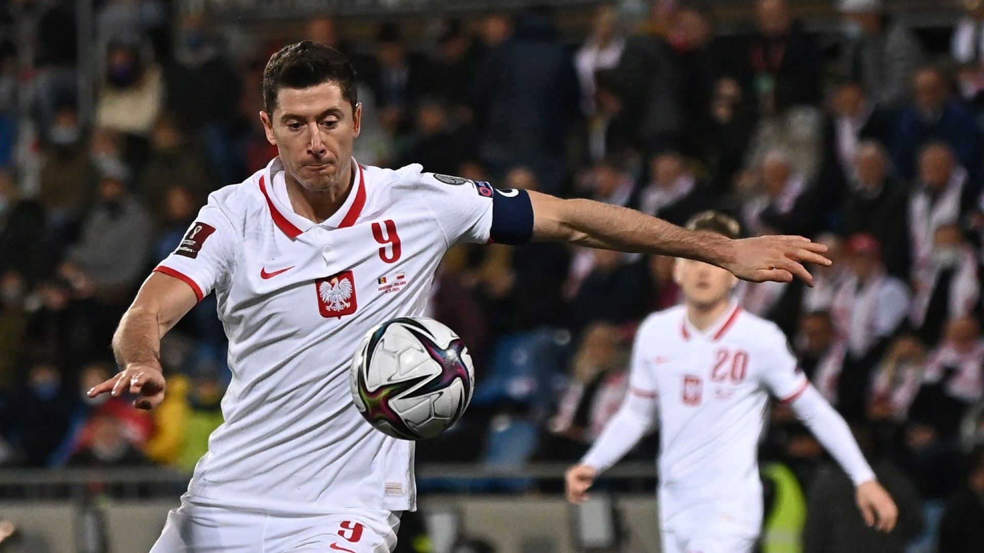 Poland's forward Robert Lewandowski (C) controls the ball 