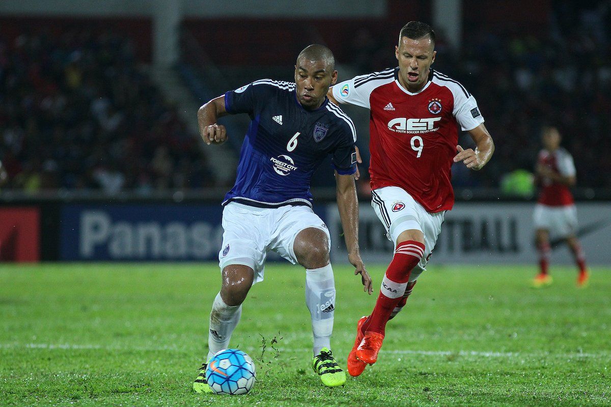 Johor Darul Ta'zim's Marcos Antonio protects the ball from South China's Nikola Komazec