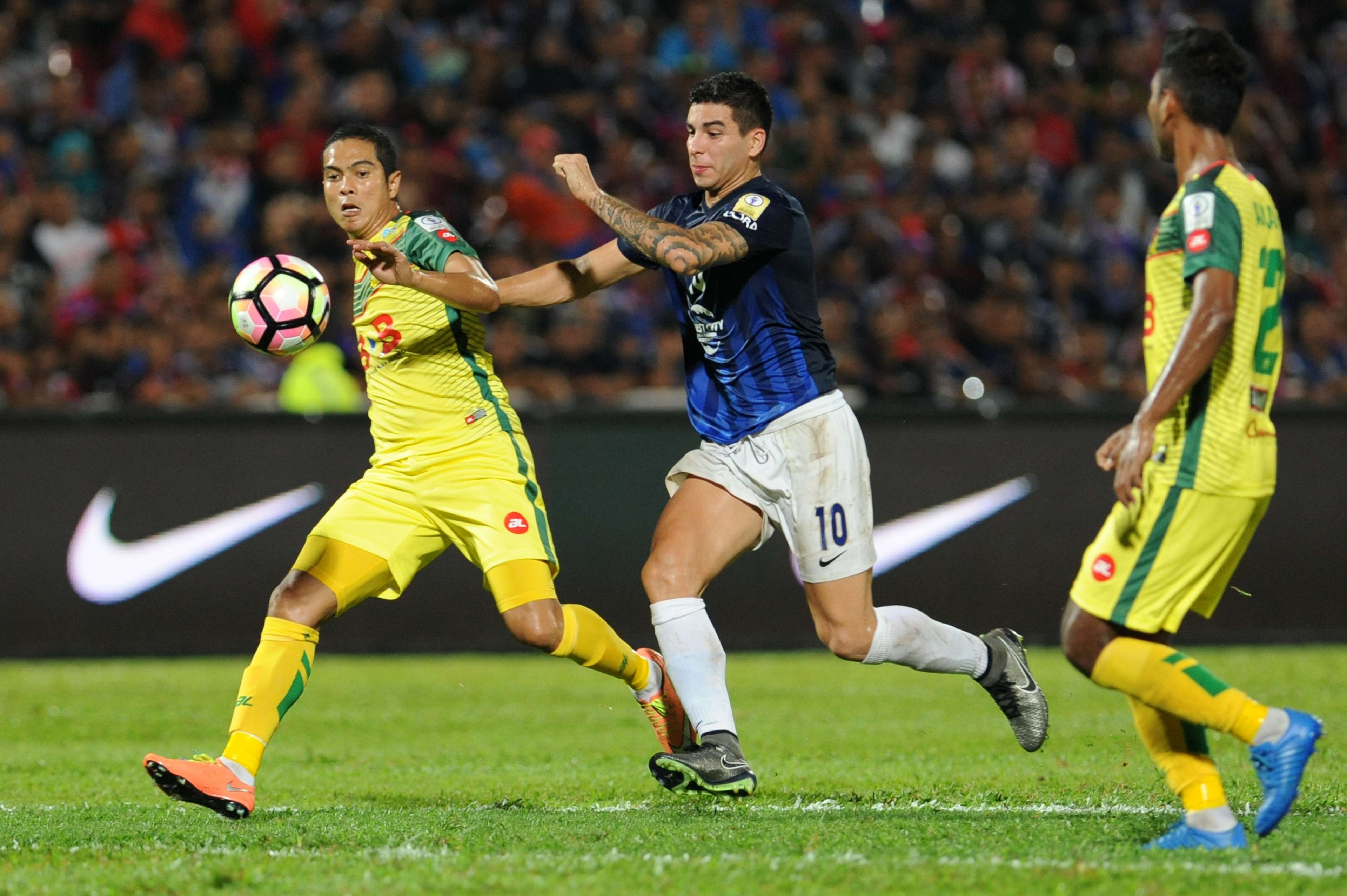 Johor Darul Ta'zim's Brian Ferreira (middle) vies for the ball with Kedah's Fitri Omar (left) 20/1/2017