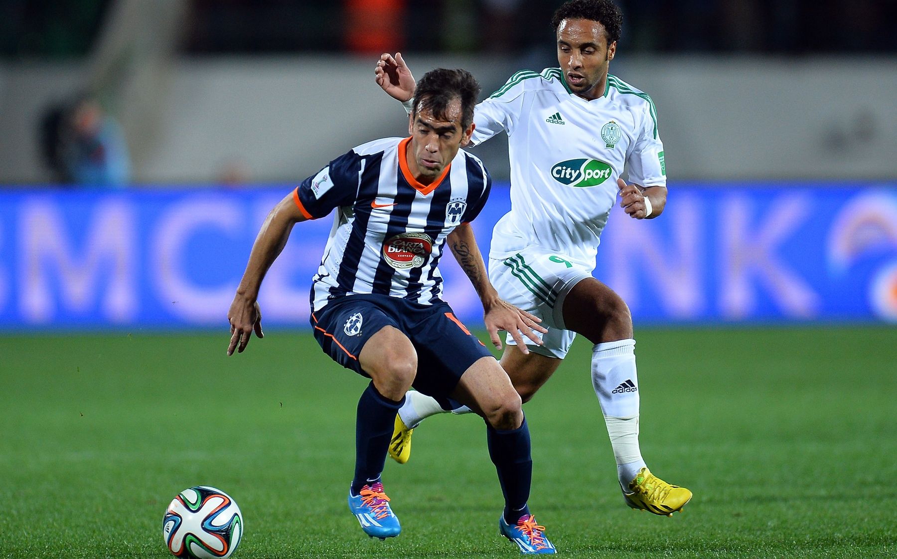 Cesar Delgado of Monterrey is challenged by Issam Erraki Raja Club World Cup 2013