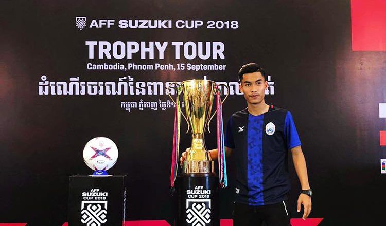 Cambodian national team player Brak Thiva poses alongside the AFF Suzuki Cup.
