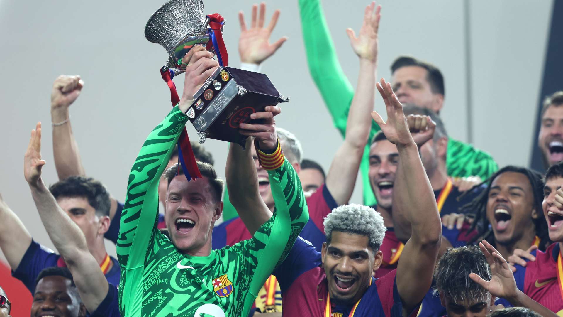 Inaki Pena and Ronald Araujo of FC Barcelona celebrate with the Supercopa de Espana trophy 2025