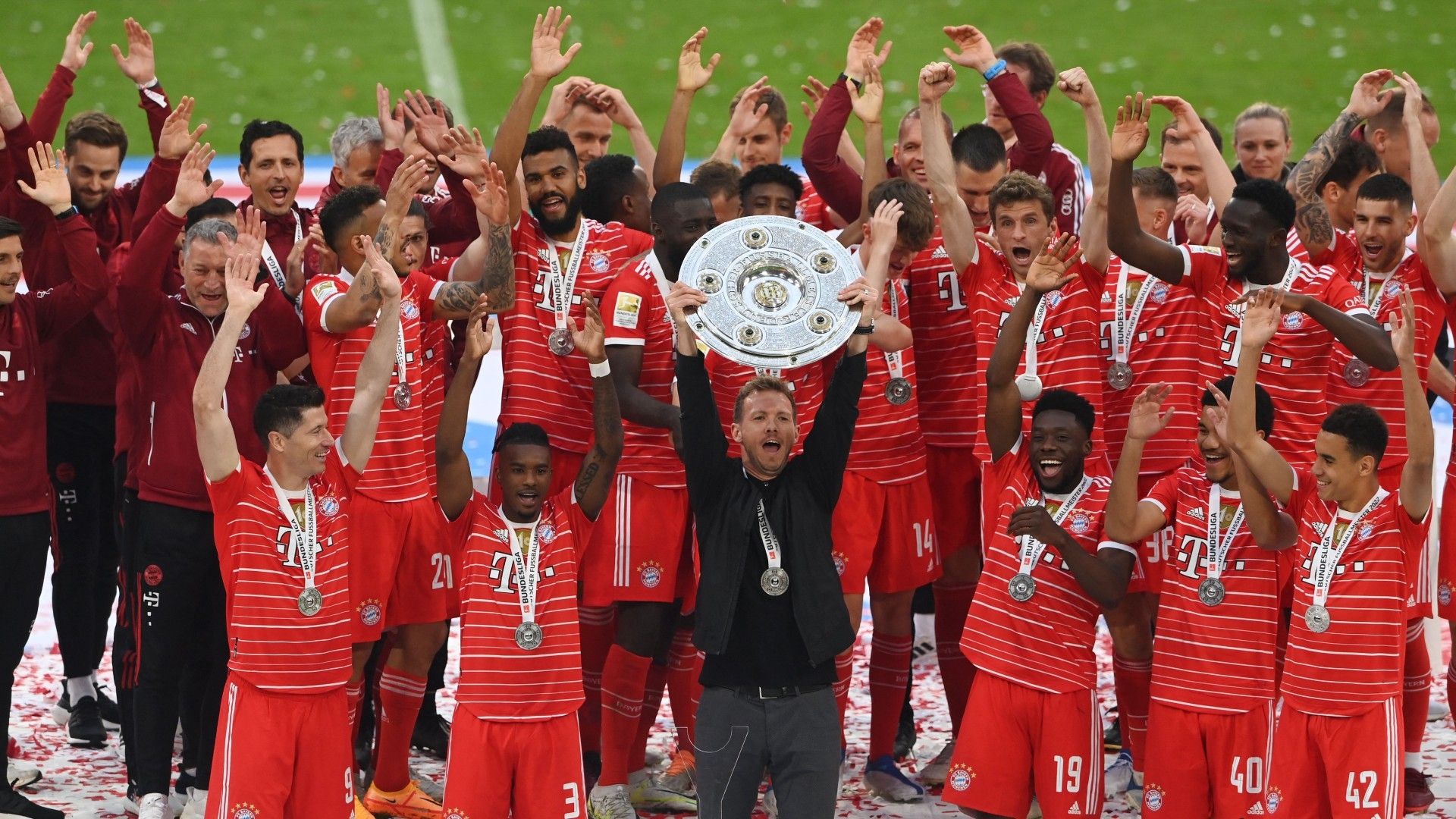 Bayern Munich's German head coach Julian Nagelsmann holds the trophy as Bayern Munich players celebrate 
