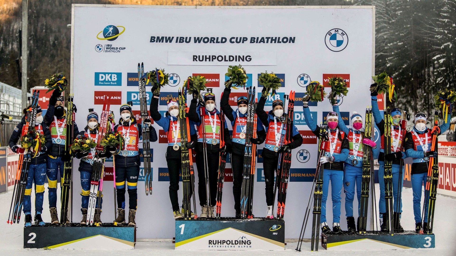 The temas of (L to R) second placed Sweden, winner France and third placed Russia pose on the podium of the women's 4x6km relay event