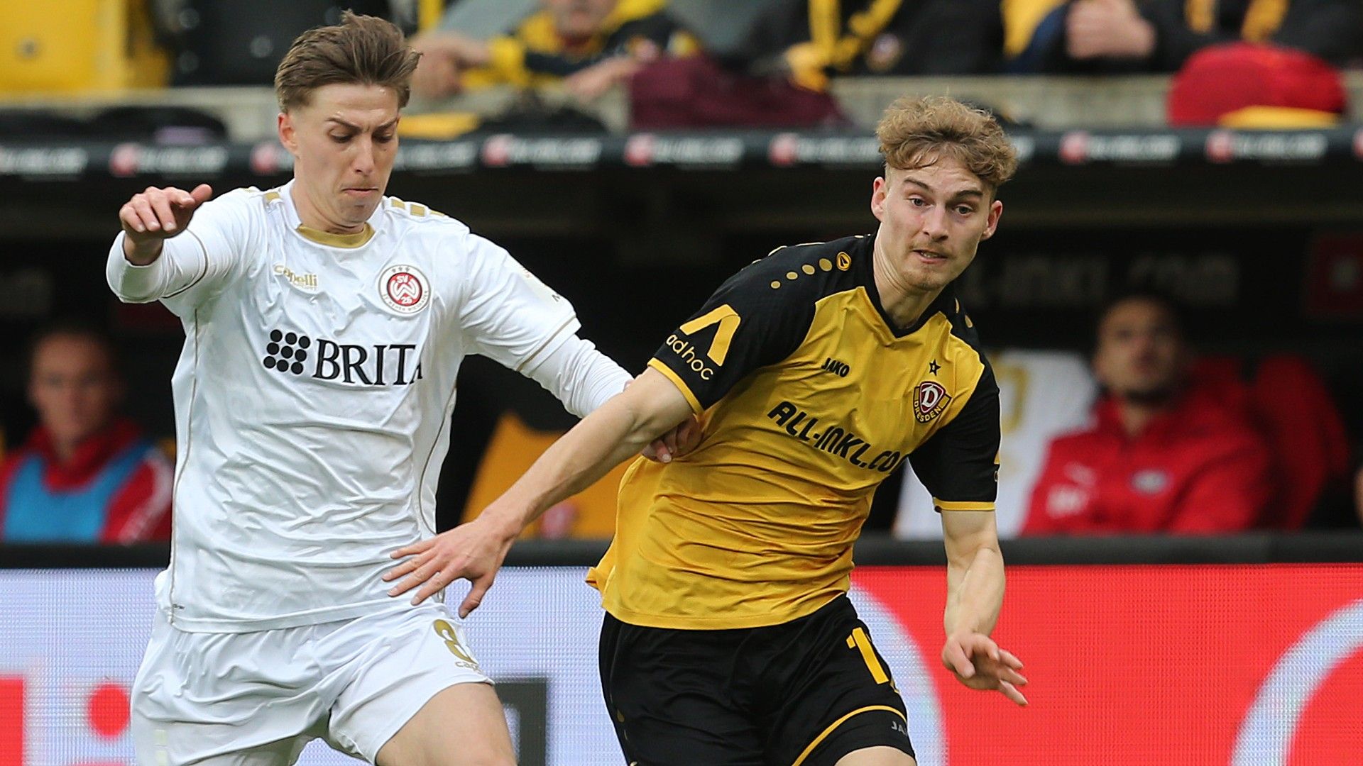 Dominik Kother (R) of Dresden challenges for the ball