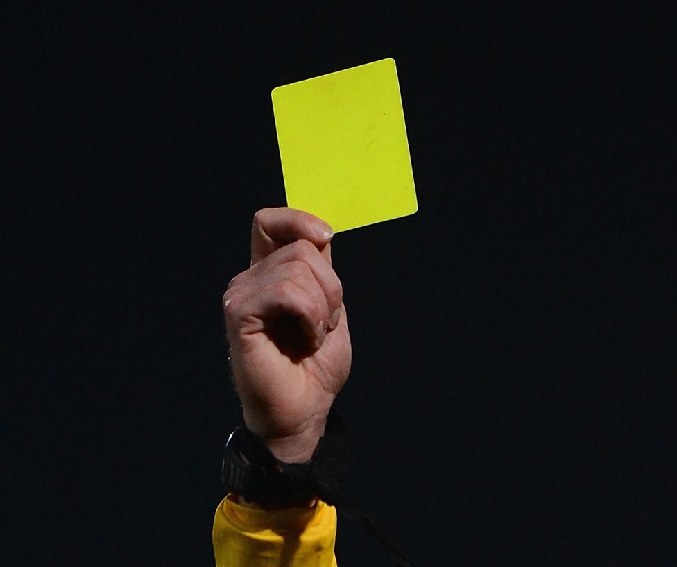 Referee hand showing a yellow card