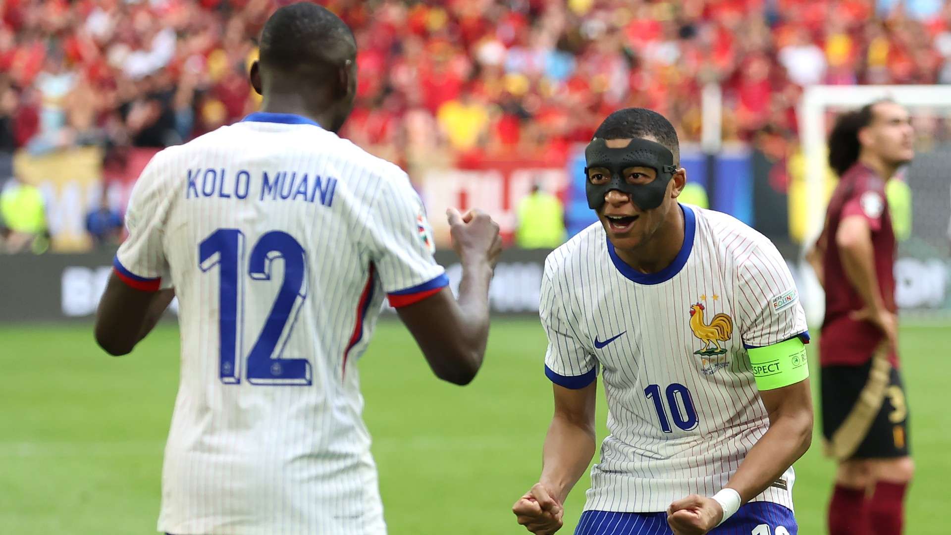 Kylian Mbappe of France, whilst wearing a Black Protective Face Mask, celebrates after teammate Randal Kolo Muani
