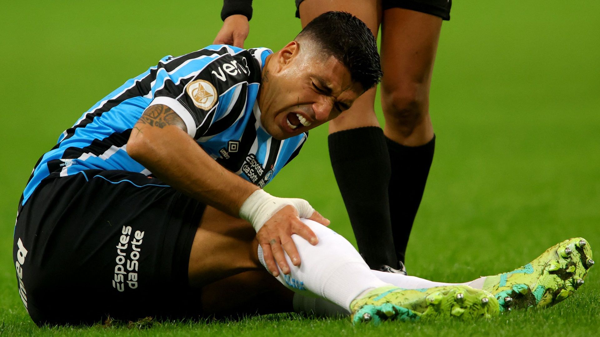 Luis Suárez sente o impacto de dor no joelho, em um Grêmio x América-MG, pelo Brasileirão 2023