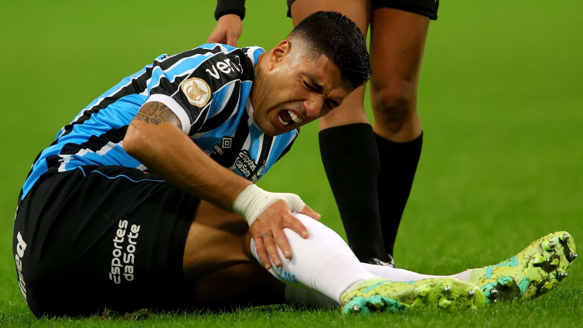 Luis Suárez sente o impacto de dor no joelho, em um Grêmio x América-MG, pelo Brasileirão 2023