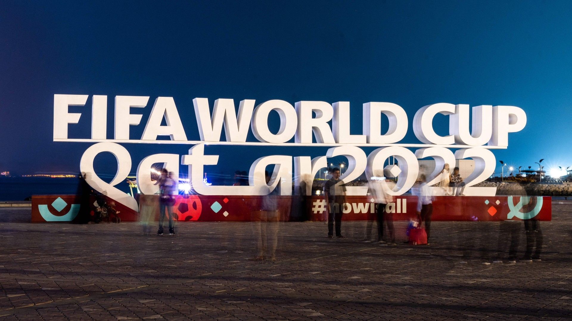 Visitors take photos with a FIFA World Cup sign in Doha