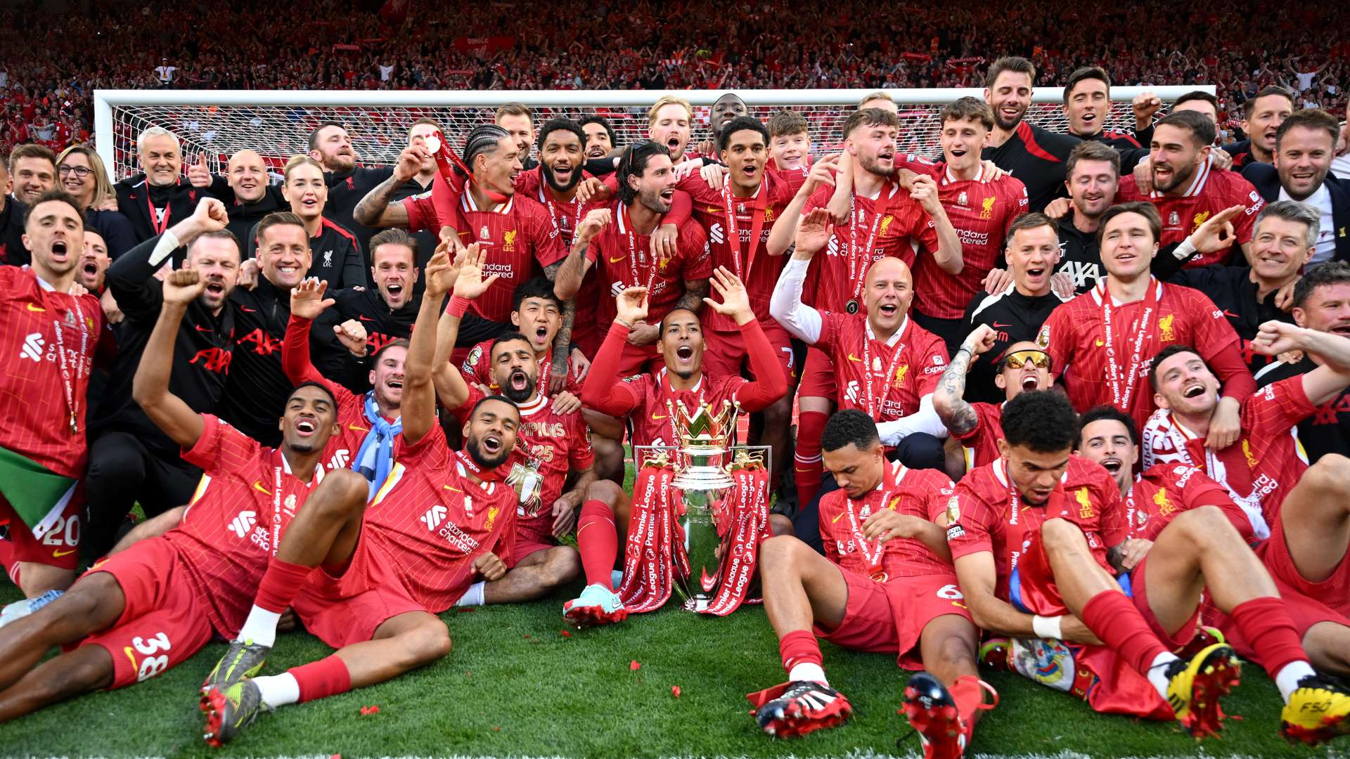 Liverpool players and staff pose for a photograph with Premier League trophy