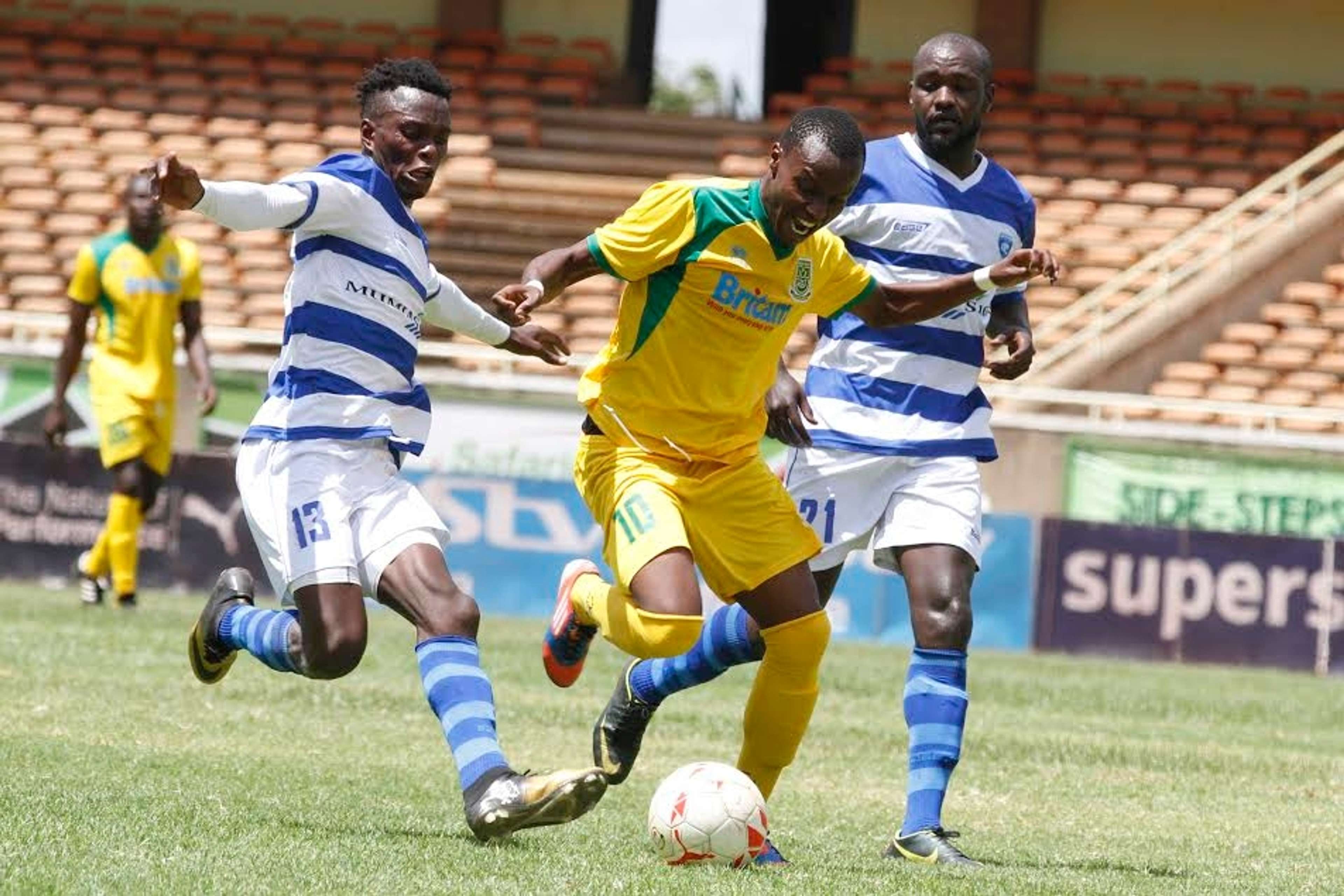 Mathare United player Daniel Mwaura dribbles past AFC Leopards' duo
