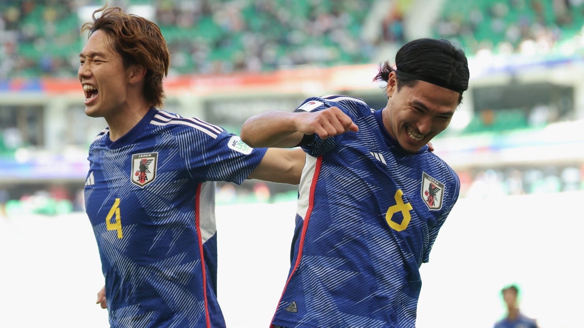 Takumi Minamino of Japan celebrates with teammate Ko Itakura