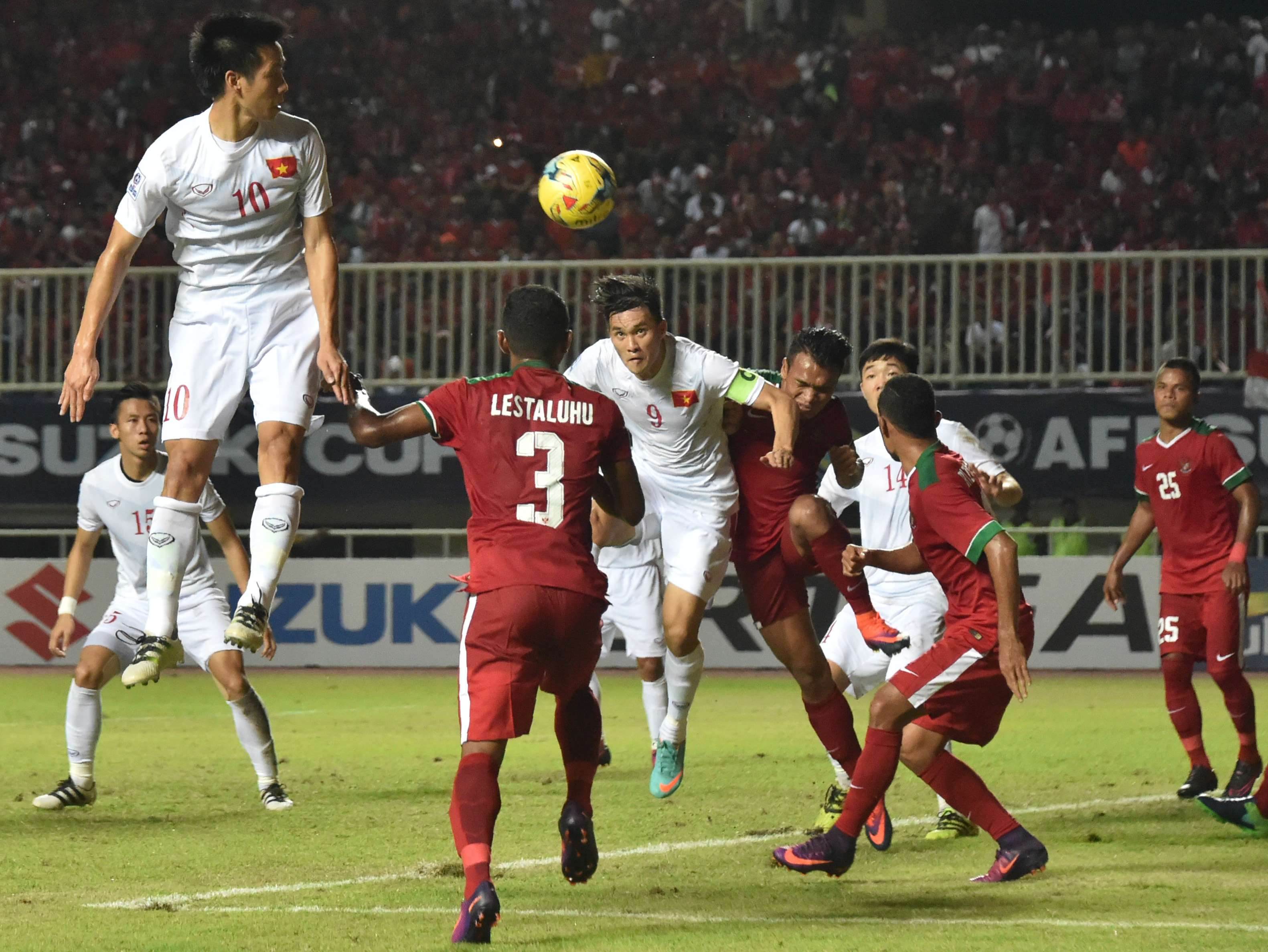 Indonesian and Vietnamese football players fight for the ball during the semi-final AFF Suzuki Cup 2016