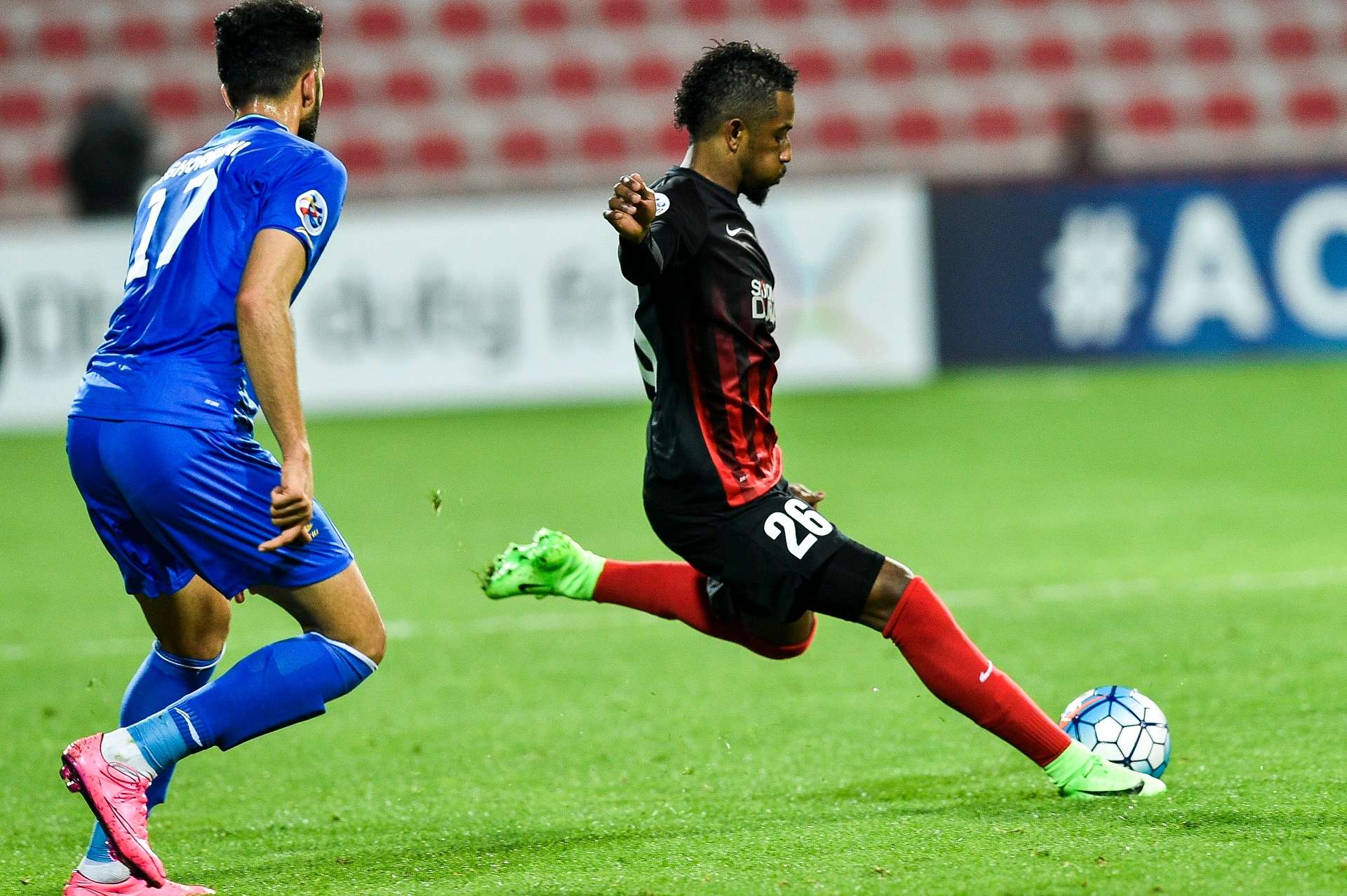 Abdulaziz Haikal (R) of UAE's Al-Ahli FC kicks the ball past Ali Ghorbani of Iran's Esteghlal FC