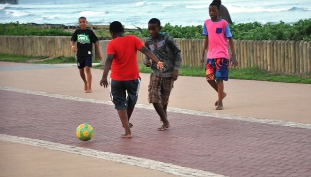 South African kids playing football by the beach