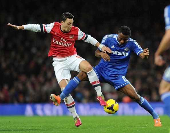 Mesut Oezil of Arsenal challenged by Mikel Obi (R) of Chelsea during the match at Emirates Stadium on Dec 23, 2013