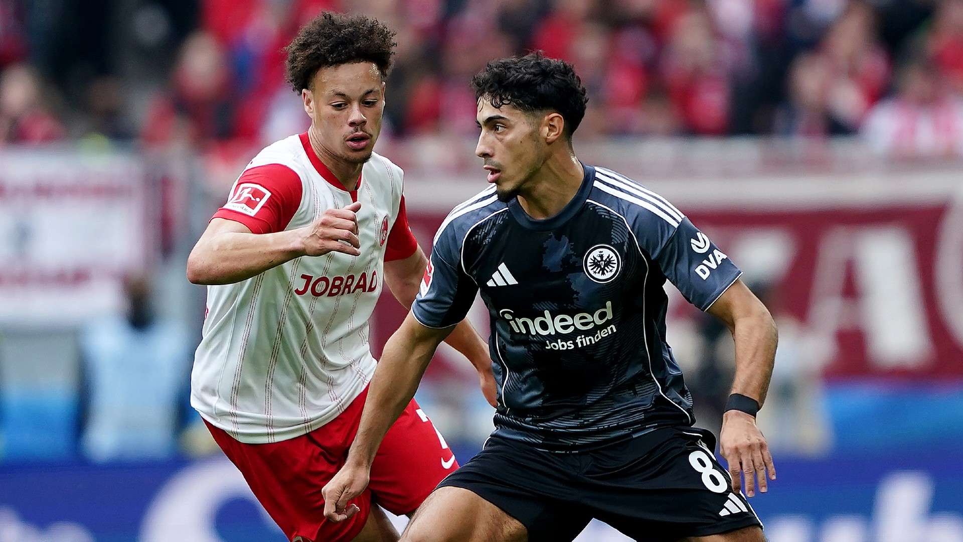Fares Chaibi of Eintracht Frankfurt is challenged by Derry Scherhant of SC Freiburg