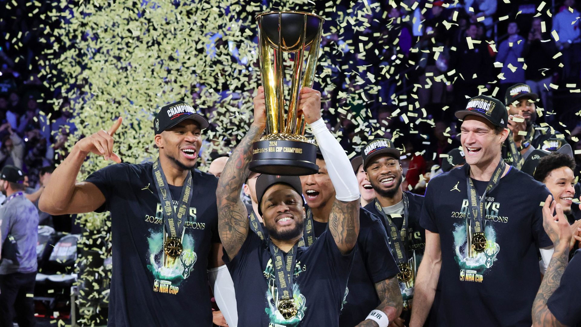 Giannis Antetokounmpo #34, Damian Lillard #0 and Brook Lopez #11 of the Milwaukee Bucks celebrate with the NBA Cup championship trophy