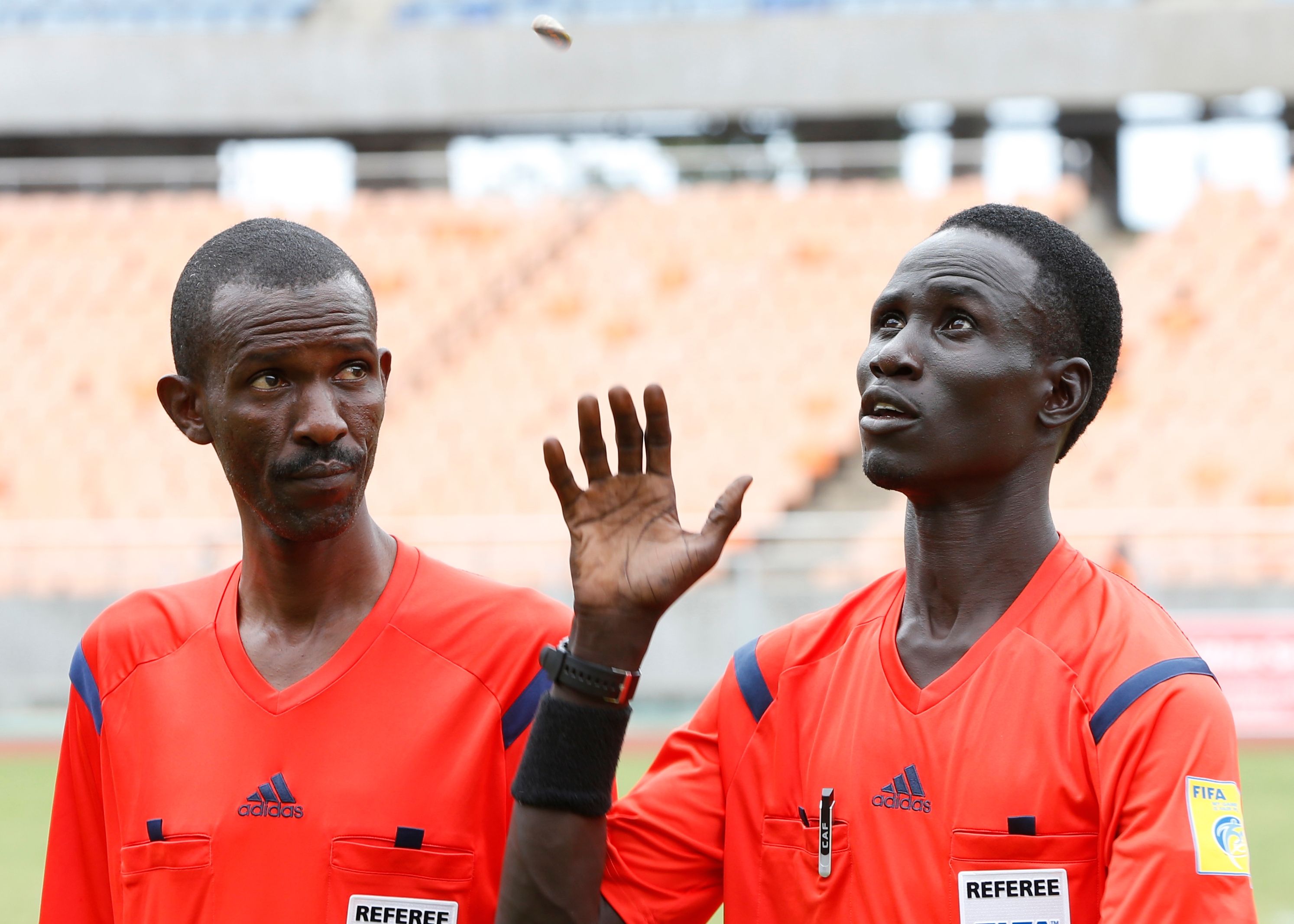 Referee Malong Ring Nyier (R) from South Sudan toss a coin before his assistant Kakunze Herve from Burundi before Telecom FC v Gor Mahia kick-off.