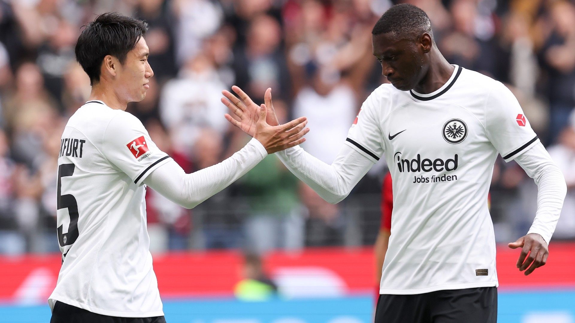 Daichi Kamada celebrates with Randal Kolo Muani of Eintracht Frankfurt
