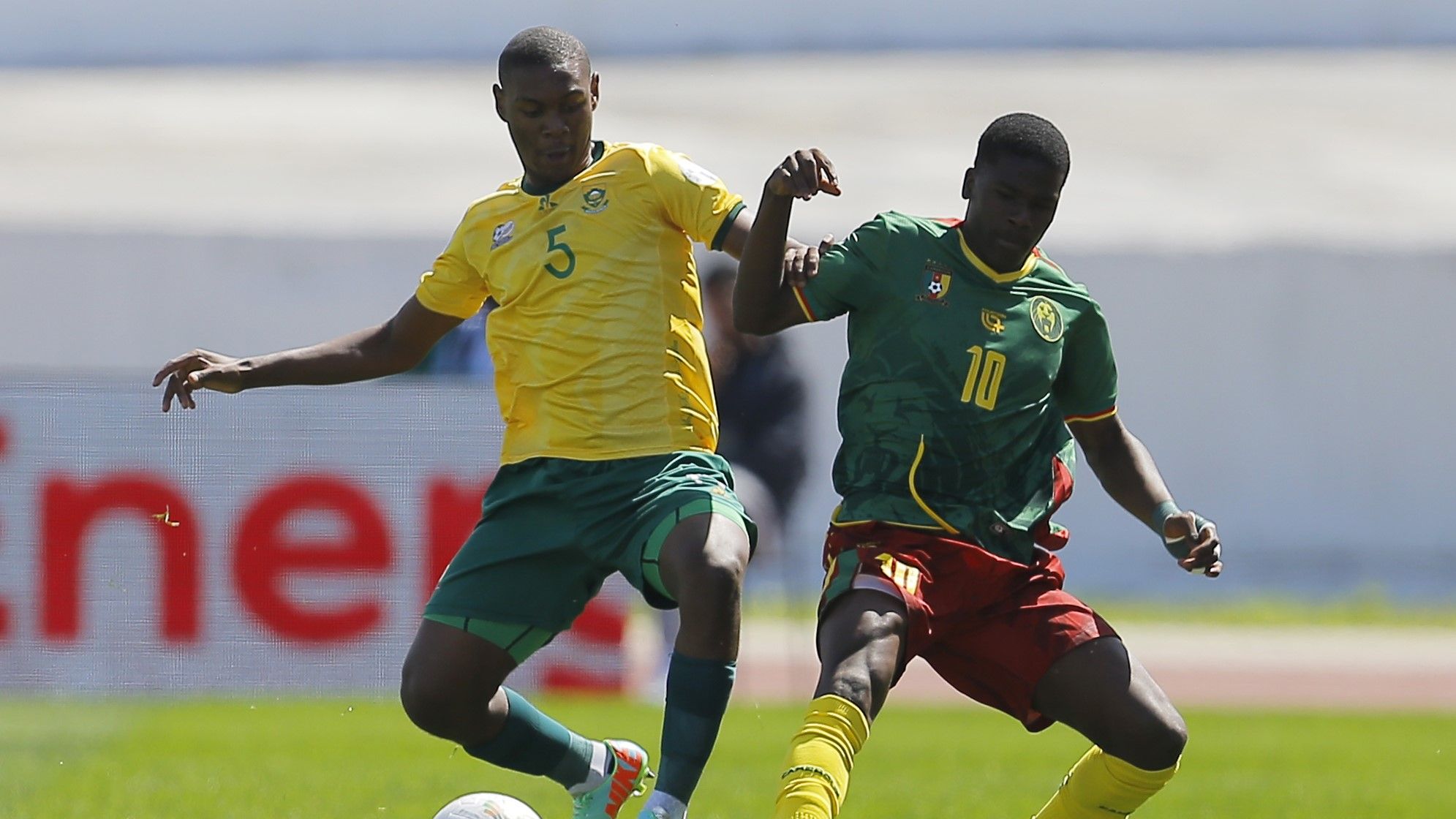 Tumi Motahpo of South Africa challenges Yannick Bondoma of Cameroon