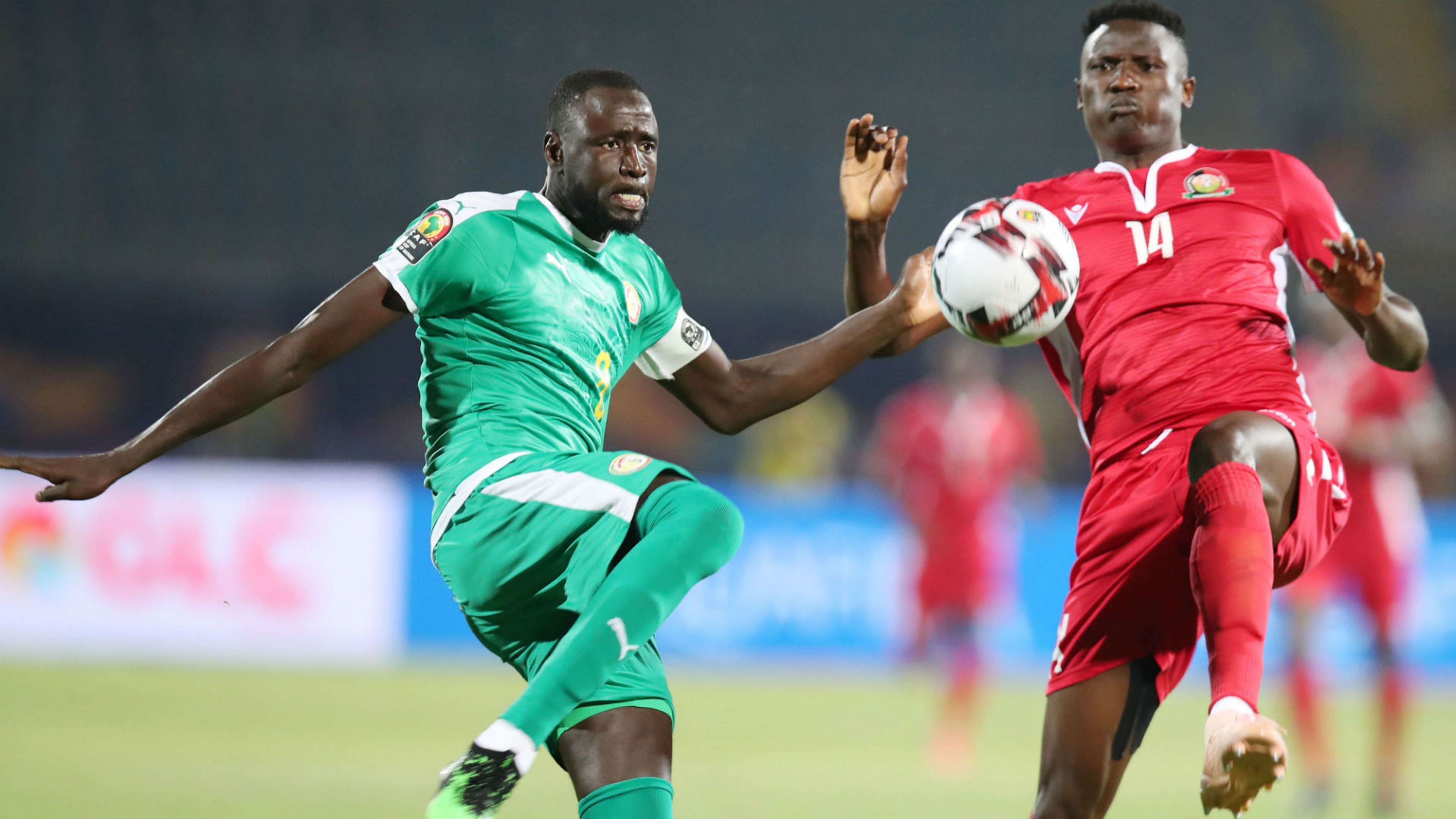 Cheikhou Kouyate of Senegal clears ball from Michael Olunga of Kenya.