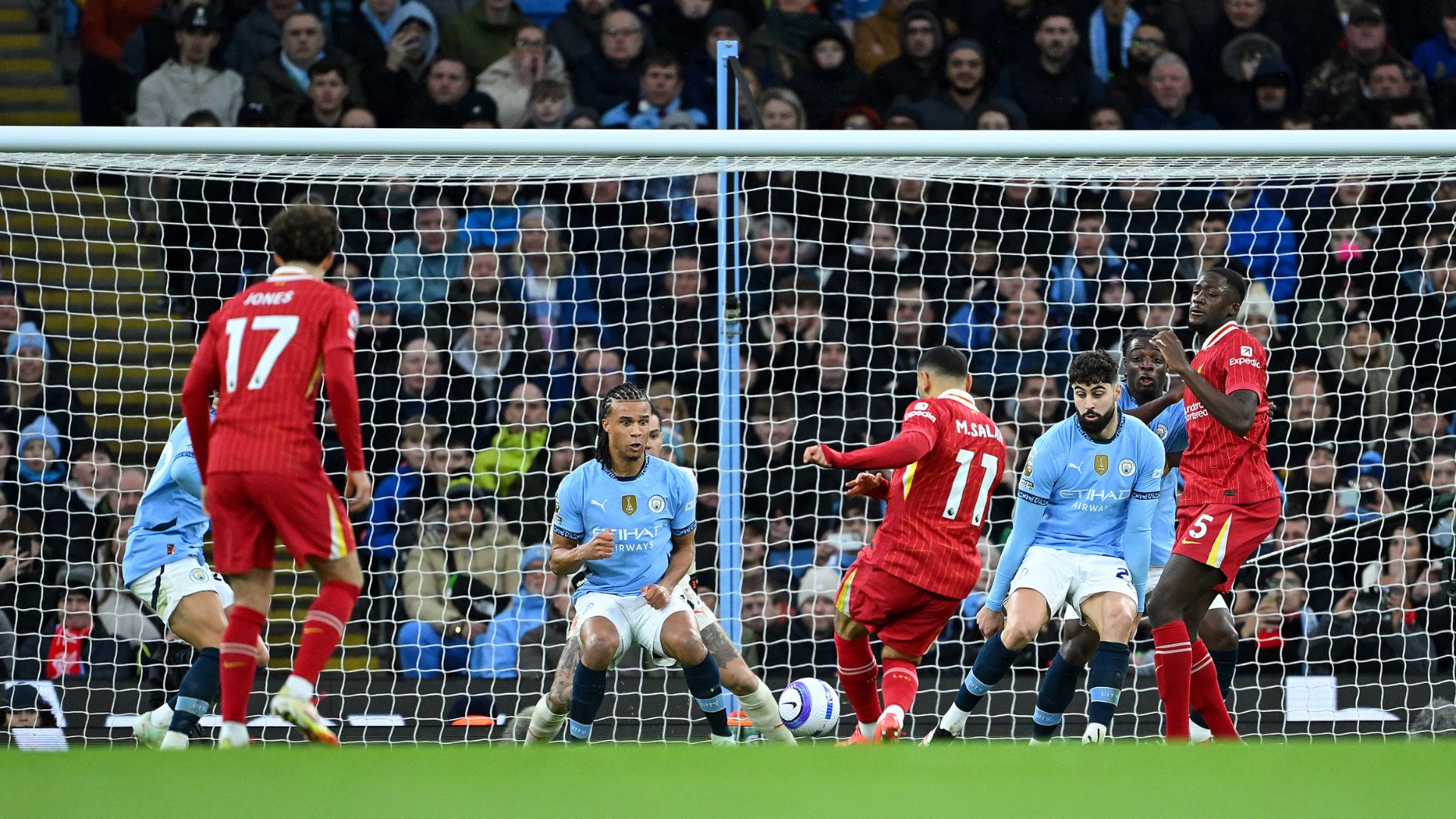 Mohamed Salah of Liverpool scores his team's first goal under pressure from Nathan Ake of Manchester City