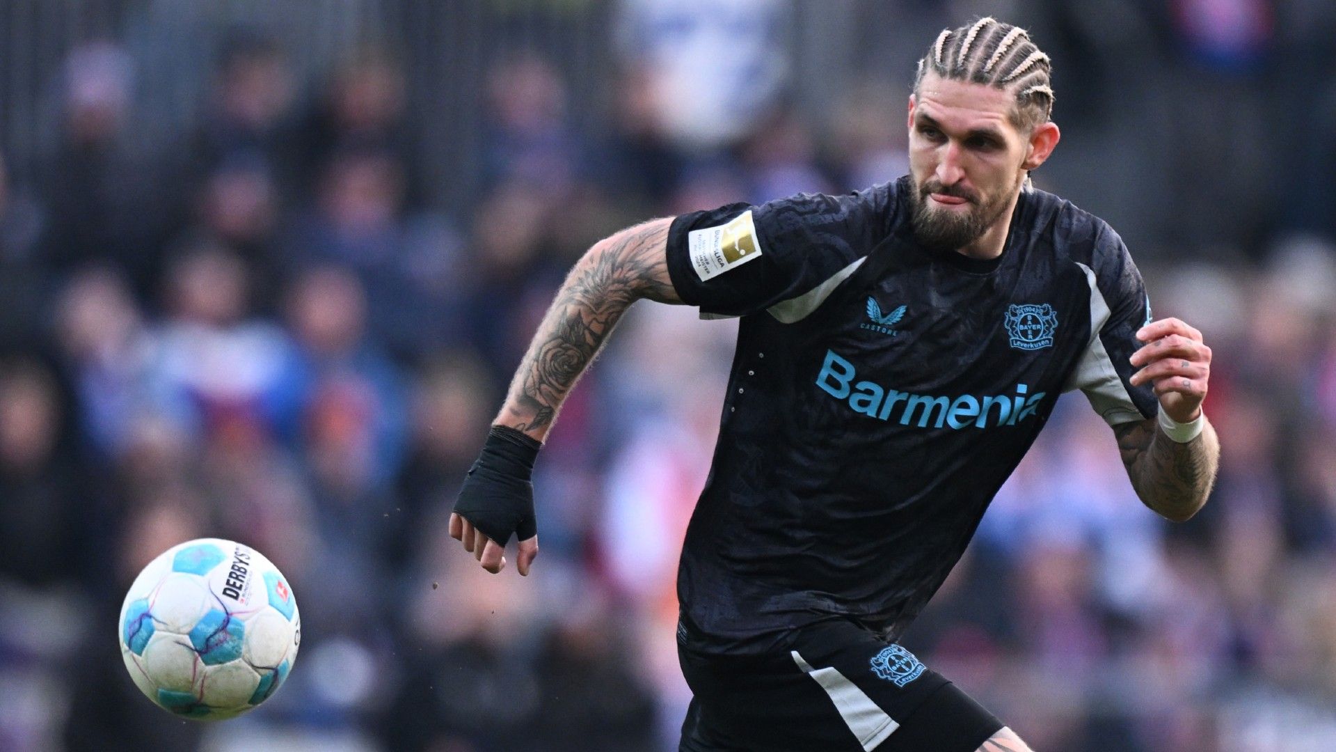 Robert Andrich of Bayer 04 Leverkusen runs with the ball during