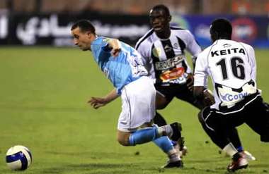 Jordanian al-Faisali club player Qusai Abu Aliyeh (L) escapes with the ball from Marcel Edico (C) and Suliman Keita (R) of Algerian Entente Setif club