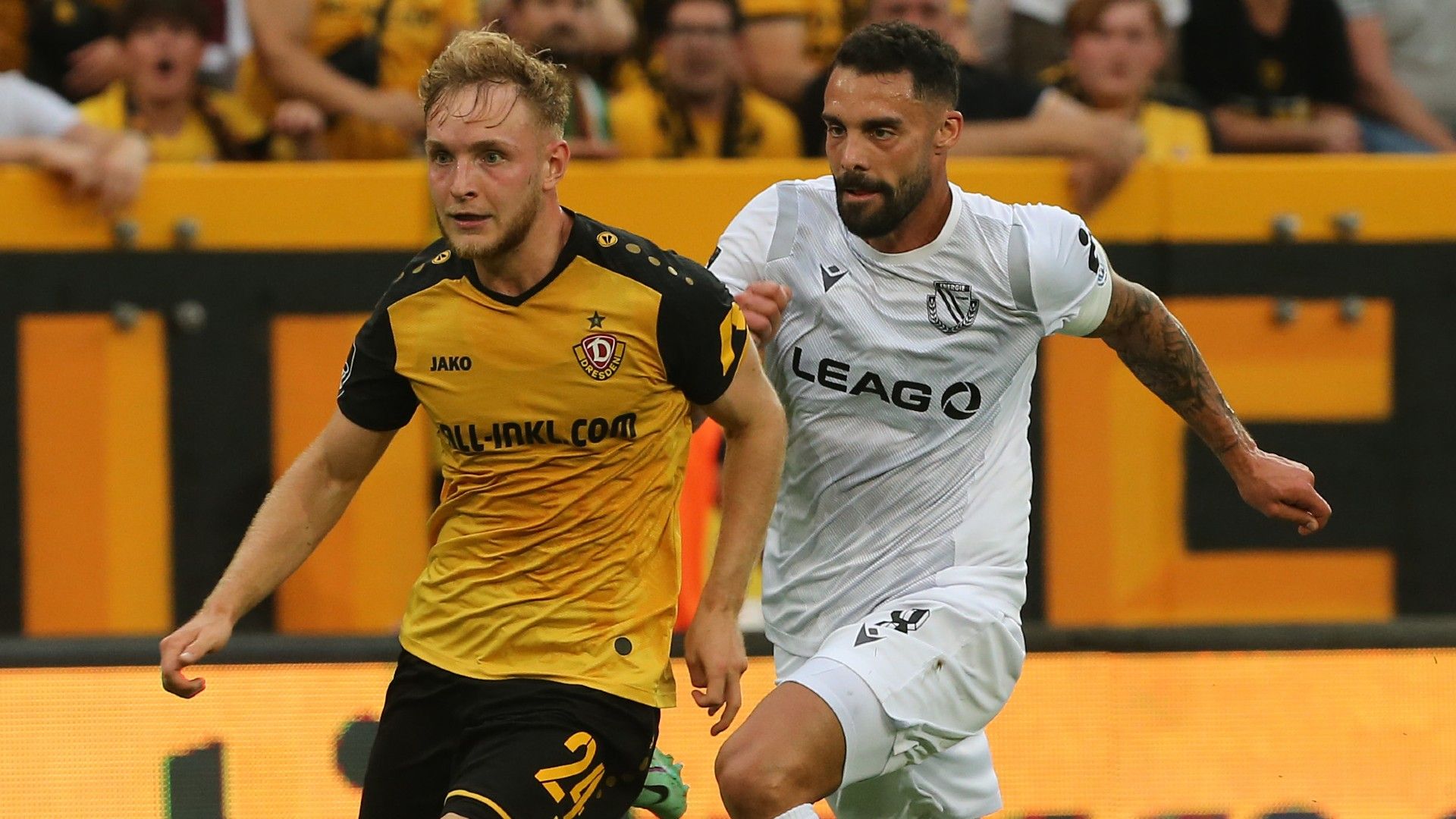 Tony Menzel (L) of Dresden challenges for the ball with Joshua Putze of Cottbus