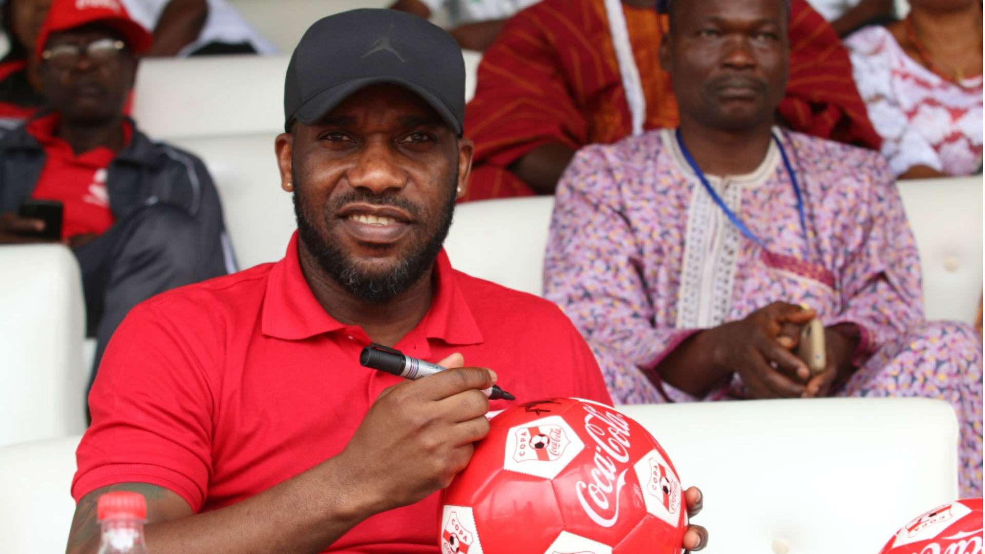 Jay Jay Okocha autographs footballs for fans