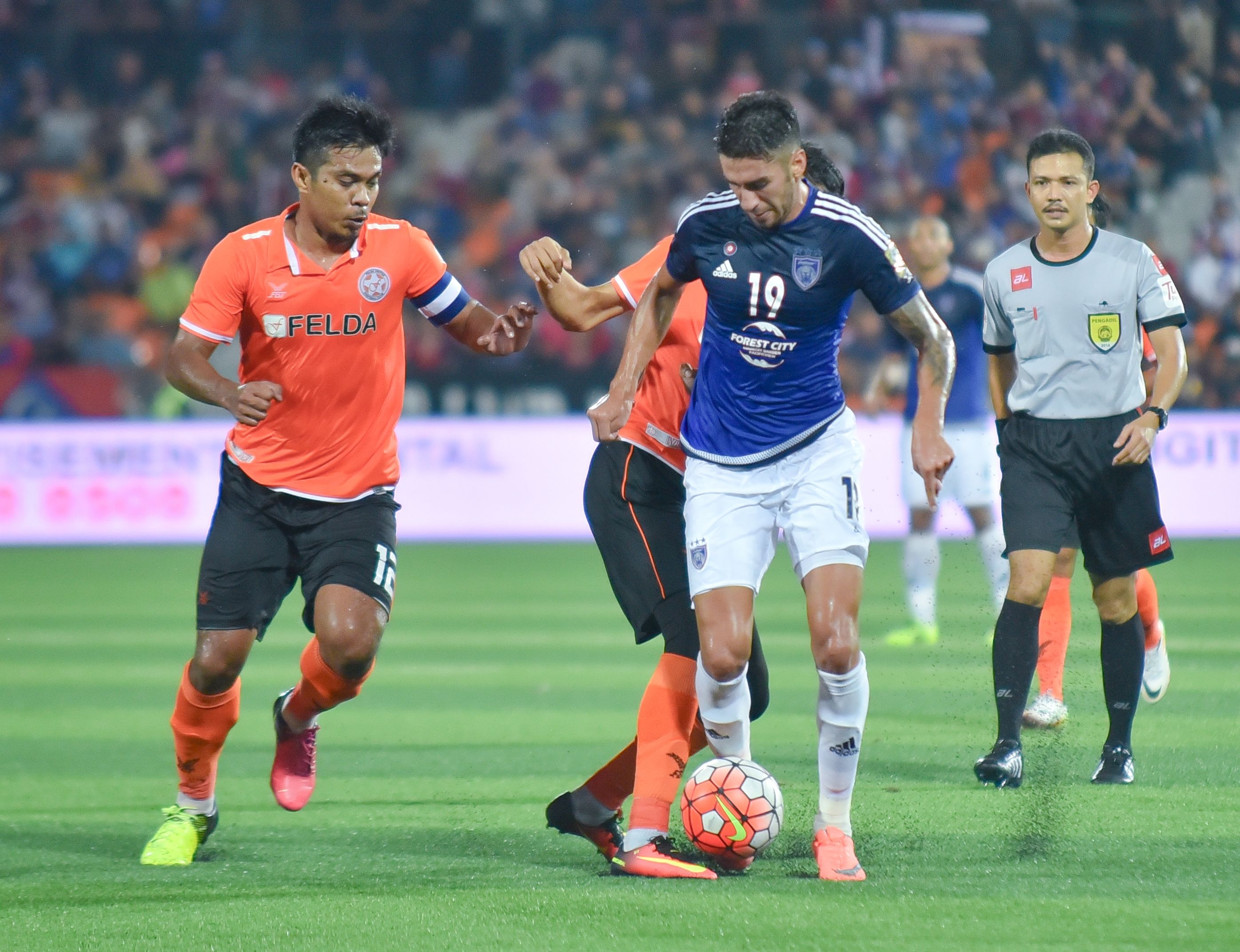 Johor Darul Ta'zim's Juan Martin Lucero (right) tries to get past Felda United's Shukor Adan (Left) 24/8/2016