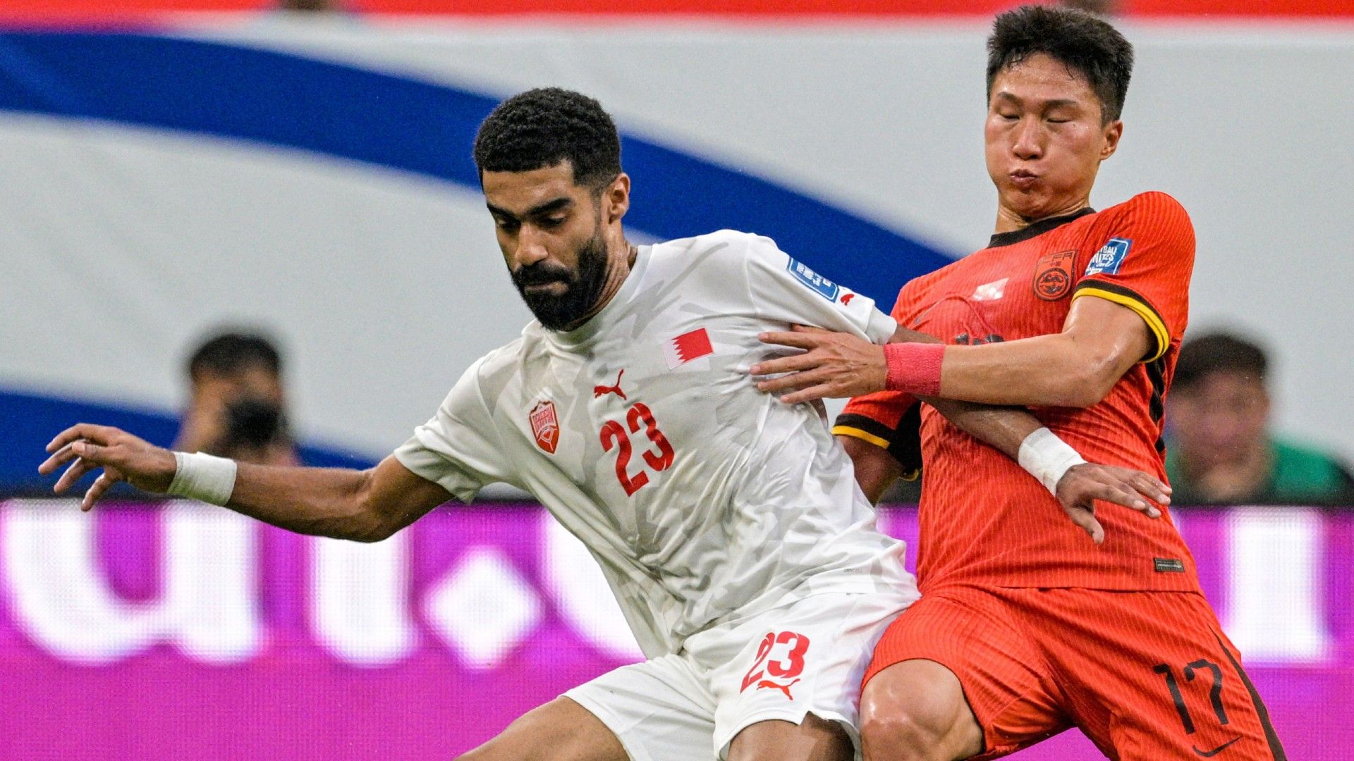 China's Yang Zexiang (R) fights for the ball with Bahrain's Abdulla Alkhalasi