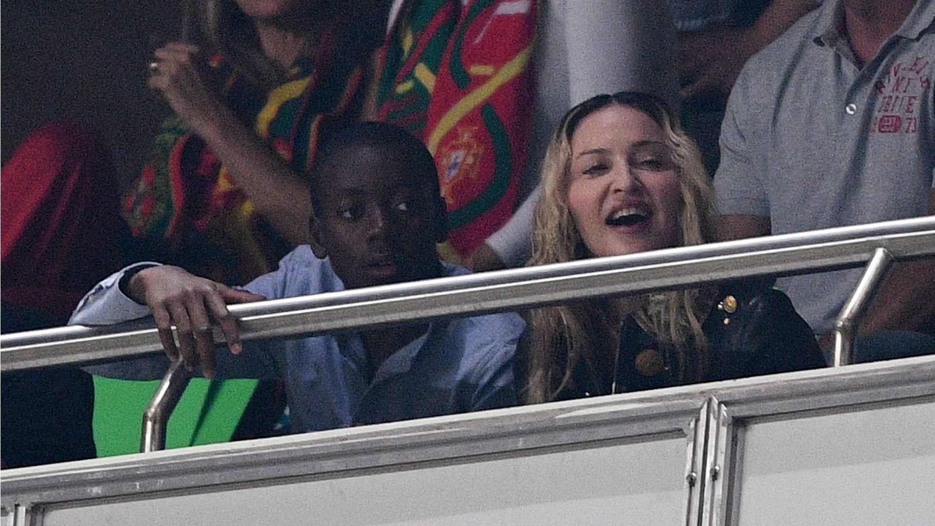 Madonna and son watching football game