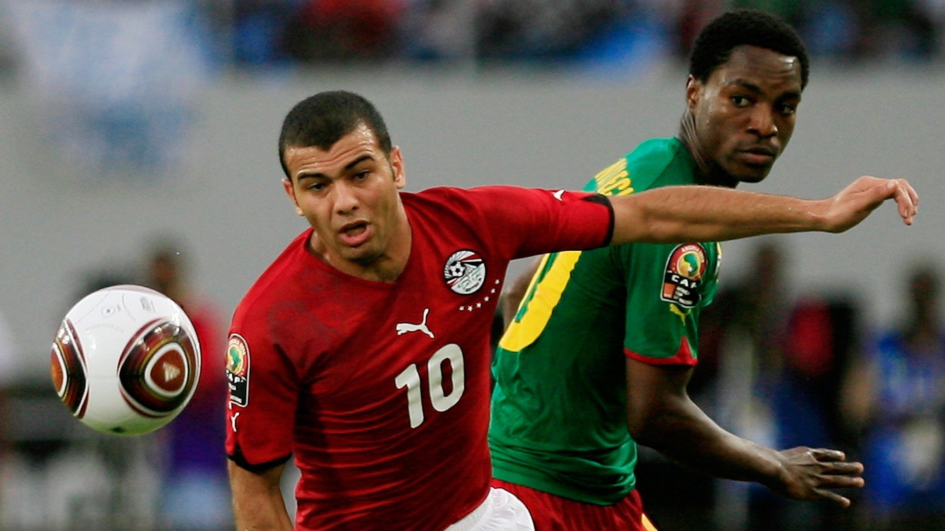 Emad Moteab (L) of Egypt vies for the ball with Mandjeck Constant of Cameroon during their quarter final match in the 2010 African Cup of Nations