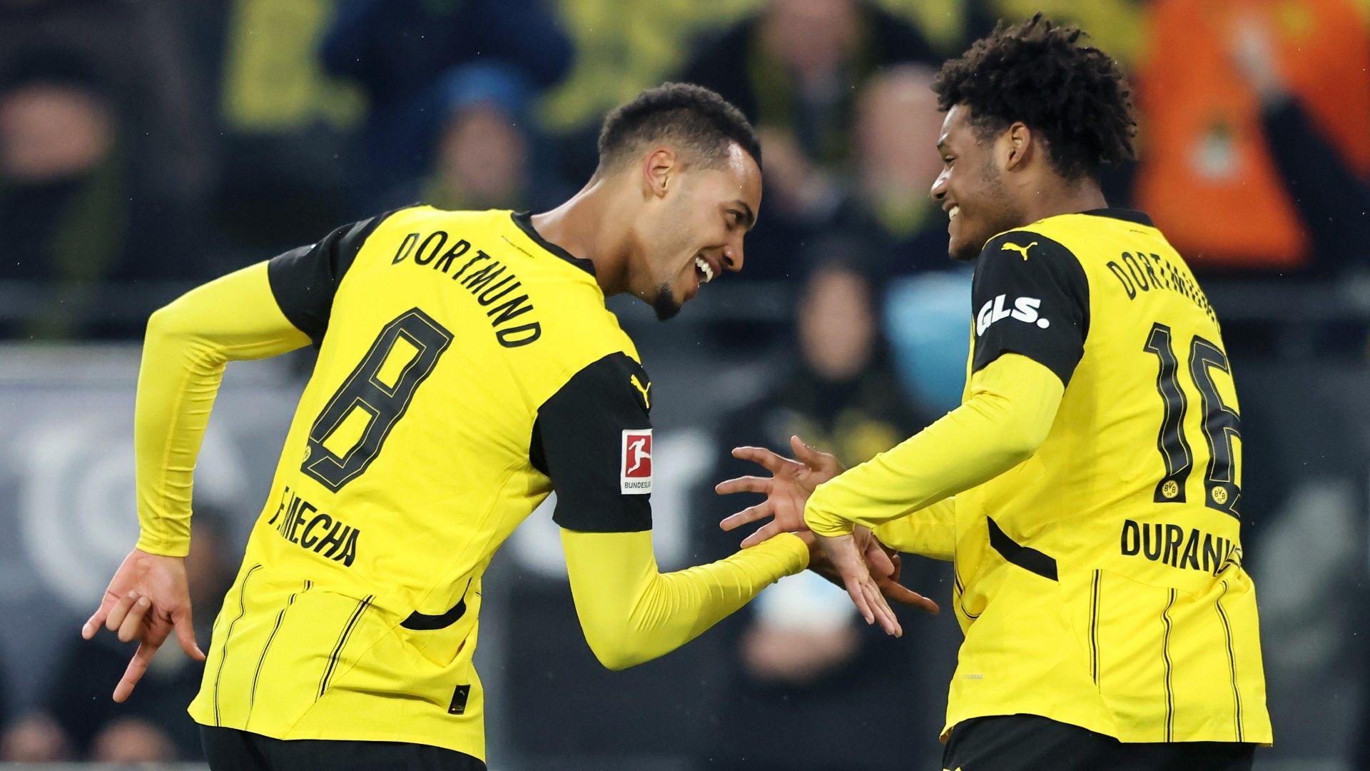 Felix Nmecha of Borussia Dortmund celebrates the team's fourth goal with teammate Julien Duranville 