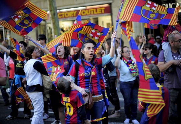 FC Barcelona's supporters wave flags as they celebrate in the streets