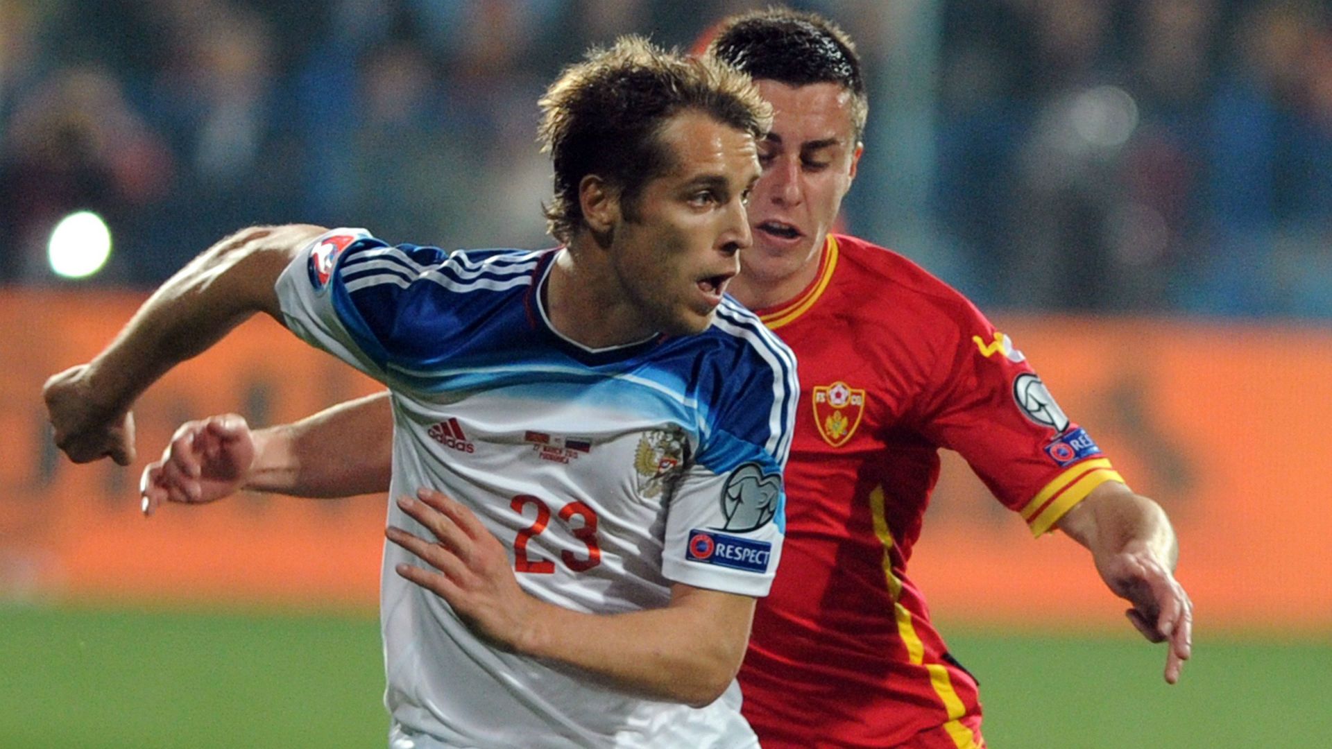 Russia's Dmitri Kombarov (L) challenges Montenegro's Adam Marusic during the Euro 2016 group G qualifying football match between Montenegro and Russia