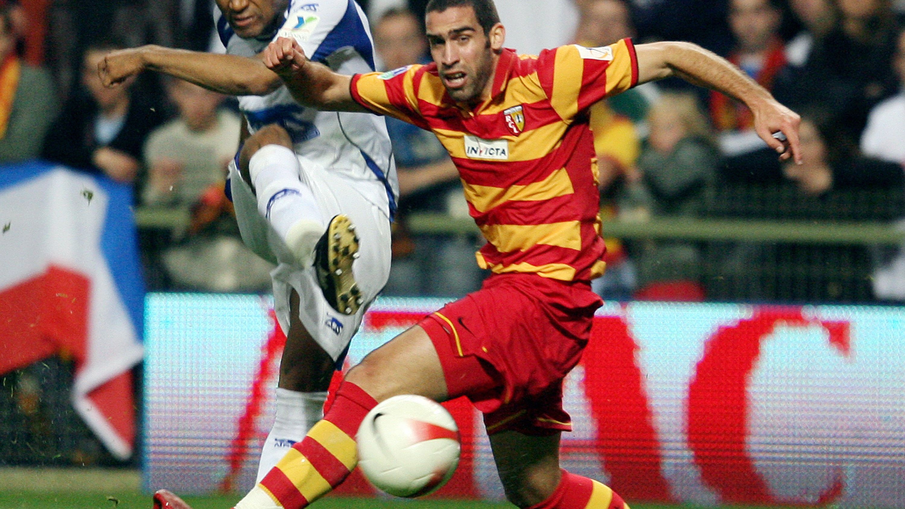 Lens's defender Fabien Laurenti (R) vies
