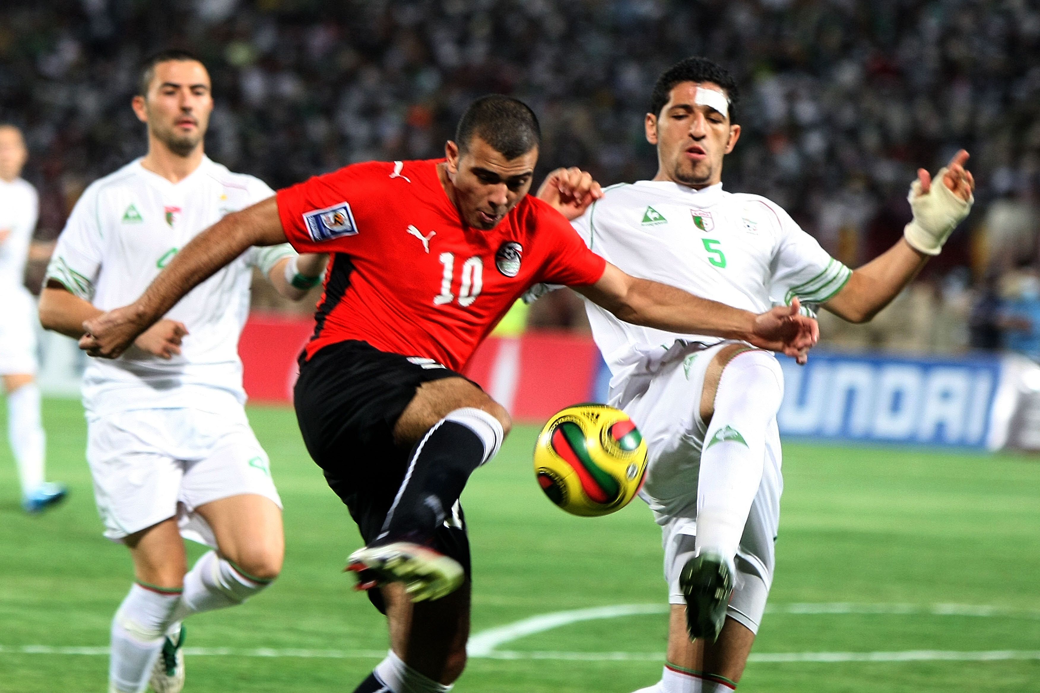 Algeria's Rafik Halliche (R) challenges